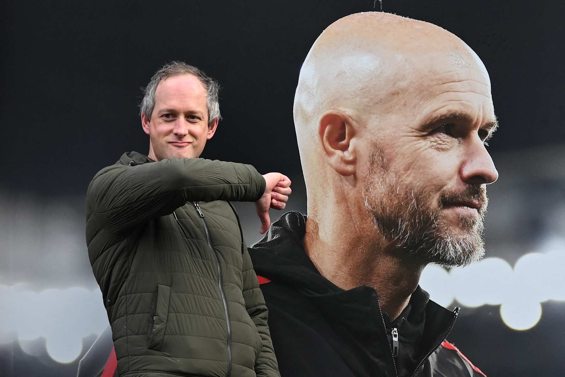 A visitor reacts as he poses in front of a picture of newly sacked Manchester United's Dutch manager Erik ten Hag, outside Old Trafford, in Manchester, north west England, on October 28, 2024. Manchester United sacked manager Erik ten Hag on October 28, 2024 after a disastrous start to the season with former Red Devils striker Ruud van Nistelrooy named interim boss. (Photo by Paul ELLIS / AFP) (Photo by PAUL ELLIS/AFP via Getty Images)