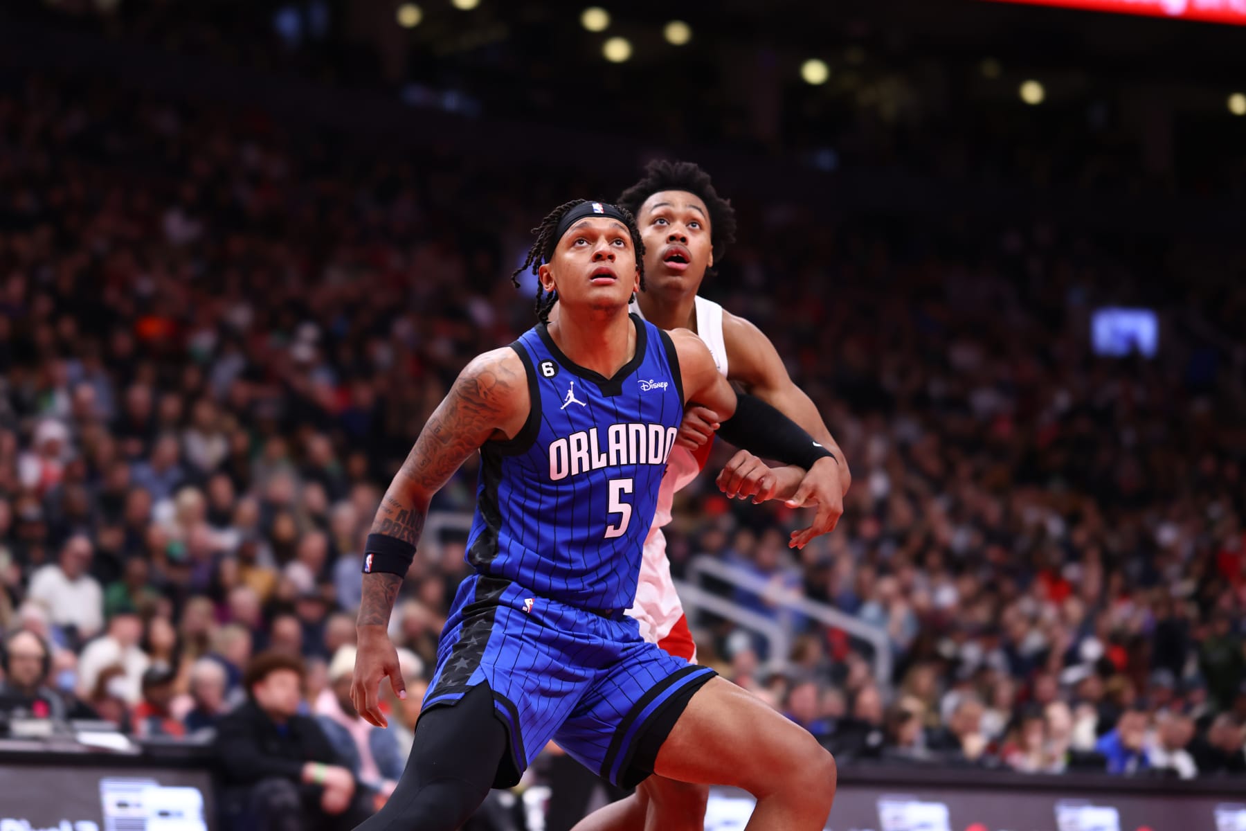 TORONTO, CANADA - DECEMBER 3: Paolo Banchero #5 of the Orlando Magic plays defense on Scottie Barnes #4 of the Toronto Raptors during the game on December 3, 2022 at the Scotiabank Arena in Toronto, Ontario, Canada.  NOTE TO USER: User expressly acknowledges and agrees that, by downloading and or using this Photograph, user is consenting to the terms and conditions of the Getty Images License Agreement.  Mandatory Copyright Notice: Copyright 2022 NBAE (Photo by Vaughn Ridley/NBAE via Getty Images)