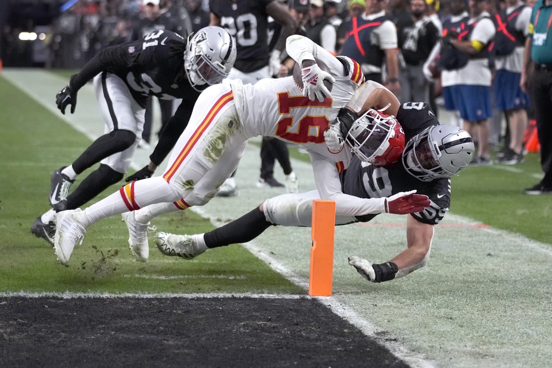 Kansas City Chiefs wide receiver Kadarius Toney (19) scores as Las Vegas Raiders linebacker Luke Masterson and cornerback Sidney Jones IV (31) defend during the first half of an NFL football game Saturday, Jan. 7, 2023, in Las Vegas. (AP Photo/John Locher)
