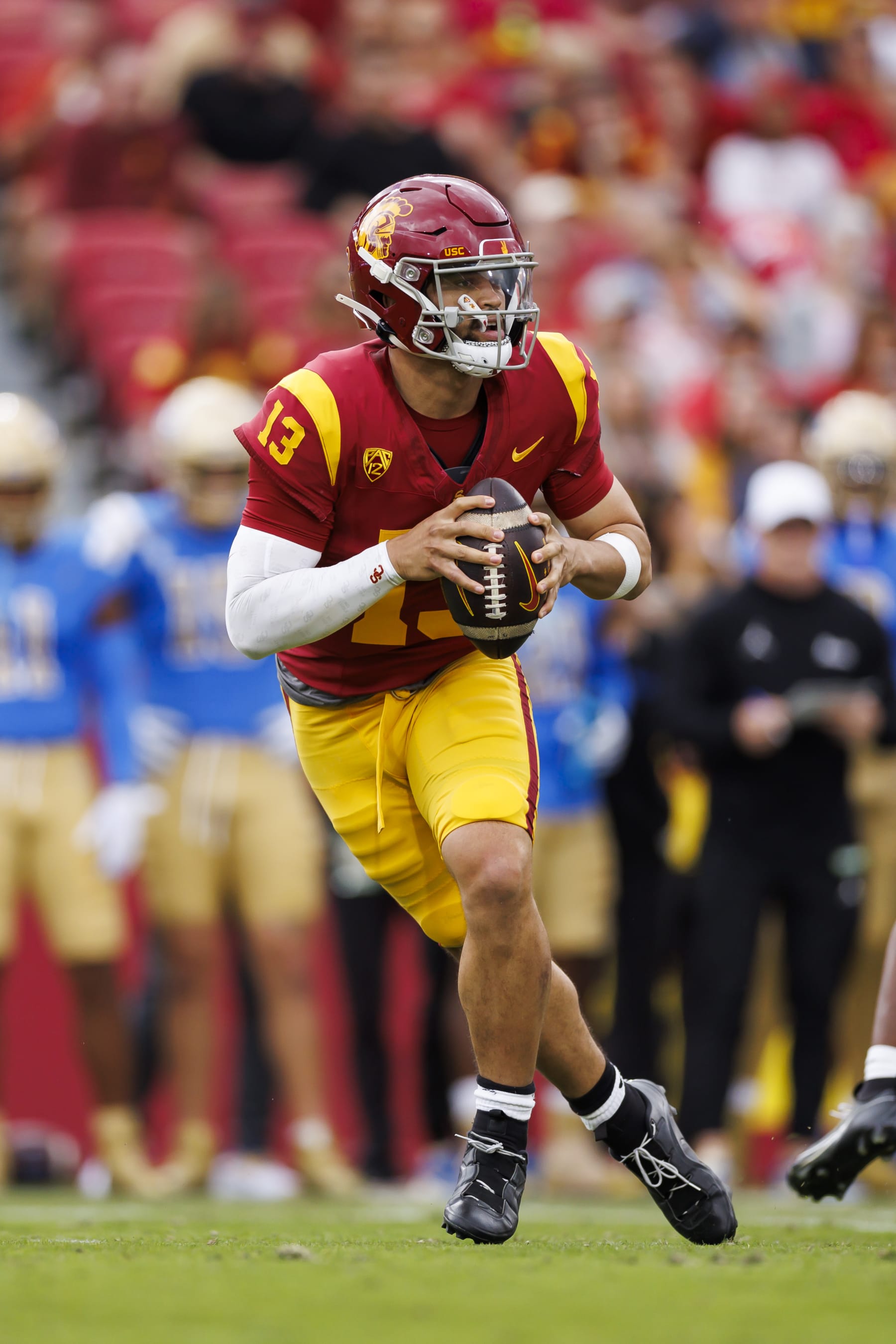 LOS ANGELES, CALIFORNIA - NOVEMBER 18: Caleb Williams #13 of the USC Trojans rolls out and looks to throw a pass during the first half of a game against the UCLA Bruins at United Airlines Field at the Los Angeles Memorial Coliseum on November 18, 2023 in Los Angeles, California. (Photo by Ryan Kang/Getty Images)