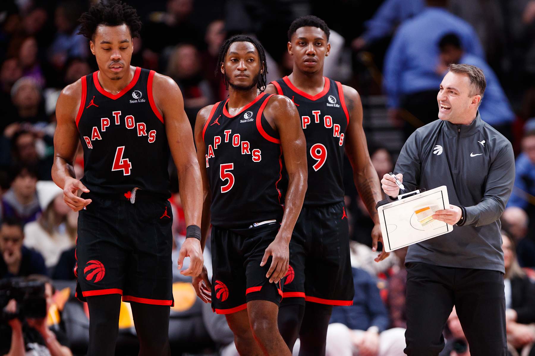 TORONTO, CANADA - JANUARY 15: Darko Rajakovic, head coach of the Toronto Raptors, talks with Scottie Barnes #4, Immanuel Quickley #5, and RJ Barrett #9 during the second half of their NBA game against the Boston Celtics at Scotiabank Arena on January 15, 2024 in Toronto, Canada. NOTE TO USER: User expressly acknowledges and agrees that, by downloading and or using this photograph, User is consenting to the terms and conditions of the Getty Images License Agreement. (Photo by Cole Burston/Getty Images)