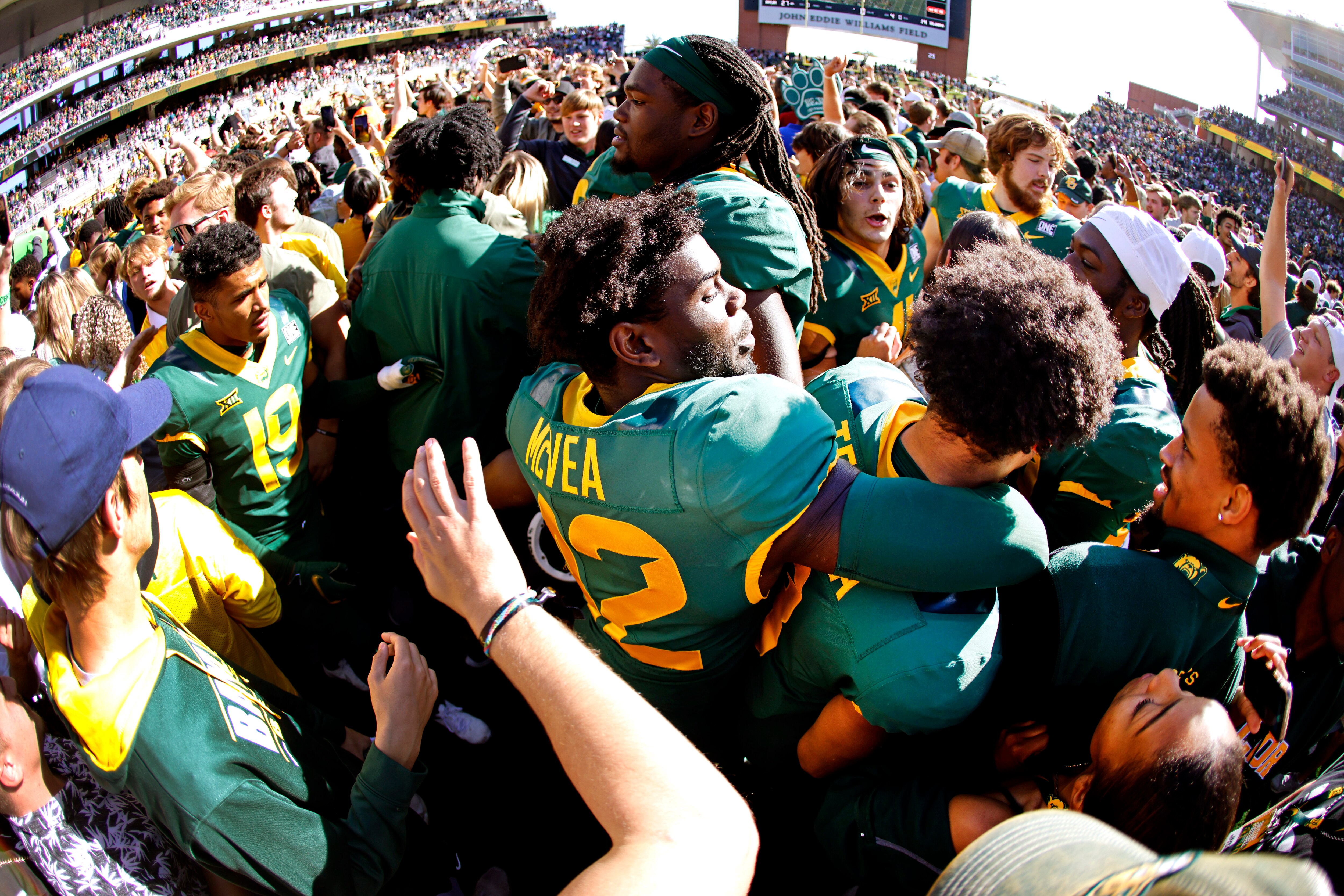 WACO, TX - NOVEMBER 13: Jairon McVea #42 of the Baylor Bears and his teammates are surrounded by fans following the teams 27-14 win over the Oklahoma Sooners  at McLane Stadium on November 13, 2021 in Waco, Texas. Baylor won 27-14. (Photo by Ron Jenkins/Getty Images)
