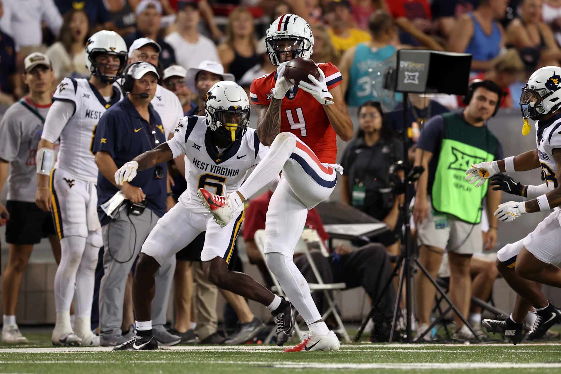 TUCSON, ARIZONA - OCTOBER 26: Wide receiver Tetairoa McMillan #4 of the Arizona Wildcats catches a pass over cornerback Jacolby Spells #6 of the West Virginia Mountaineers during the game at Arizona Stadium on October 26, 2024 in Tucson, Arizona. The Mountaineers defeated the Wildcats 31-26. (Photo by Chris Coduto/Getty Images)