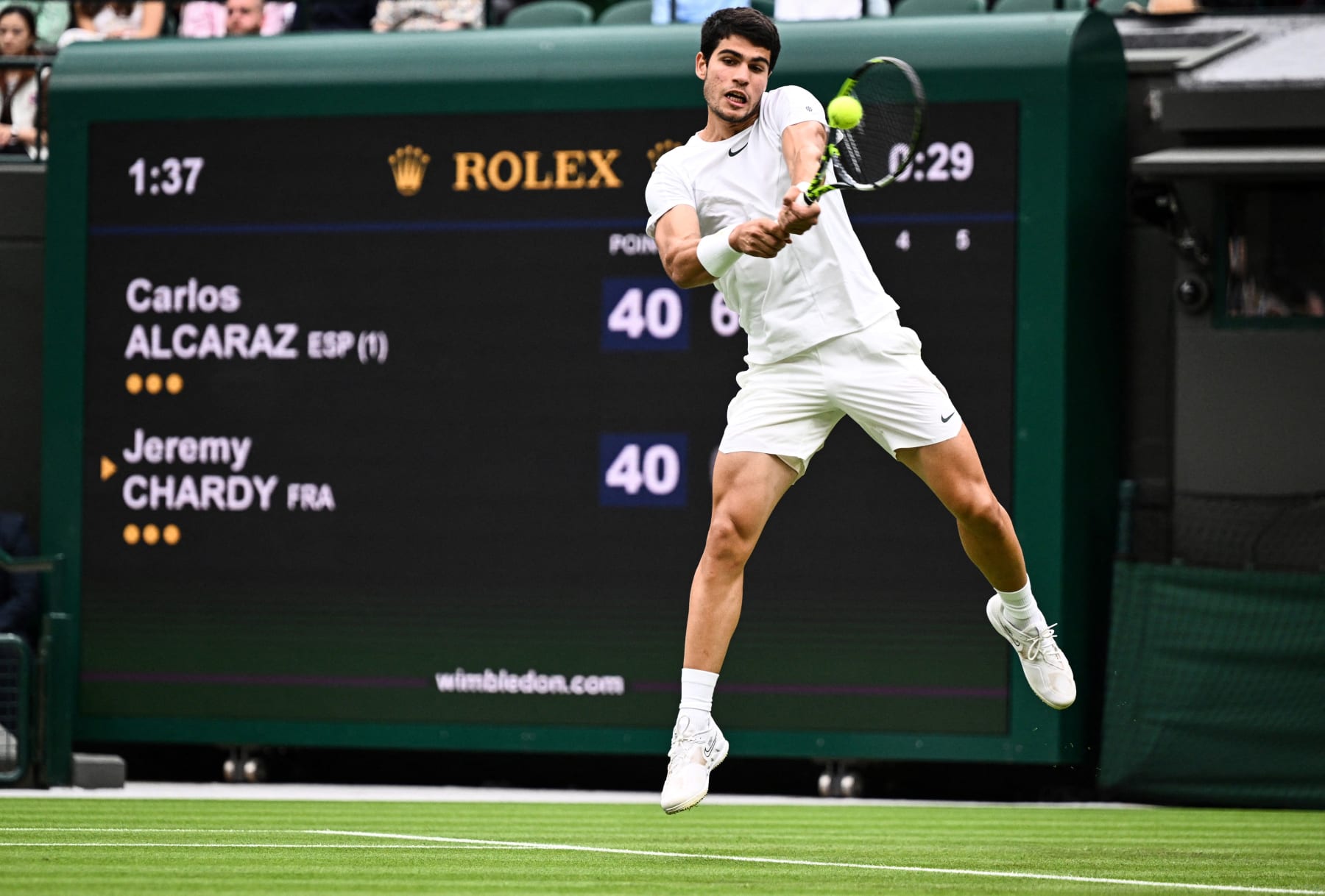 Spain's Carlos Alcaraz returns the ball to France's Jeremy Chardy  during their men's singles tennis match on the second day of the 2023 Wimbledon Championships at The All England Tennis Club in Wimbledon, southwest London, on July 4, 2023. (Photo by SEBASTIEN BOZON / AFP) / RESTRICTED TO EDITORIAL USE (Photo by SEBASTIEN BOZON/AFP via Getty Images)