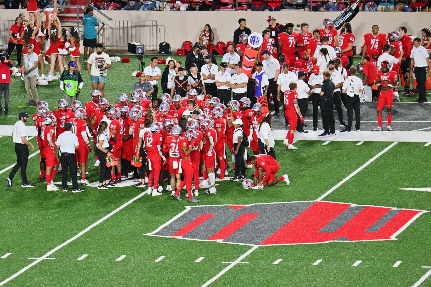 ALBUQUERQUE, NEW MEXICO - SEPTEMBER 16:  The New Mexico Lobos huddle near the Mountain West logo during the second half of their game against the New Mexico State Aggies at University Stadium on September 16, 2023 in Albuquerque, New Mexico. The Aggies defeated the Lobos 27-17.  (Photo by Sam Wasson/Getty Images)