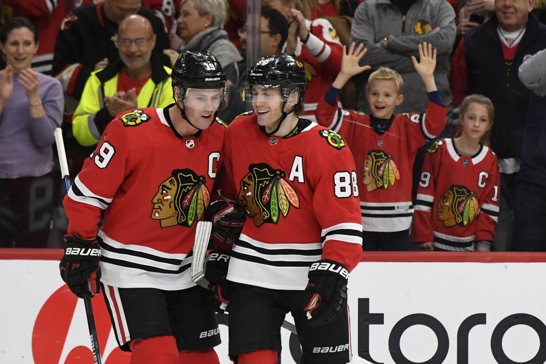 FILE - Chicago Blackhawks' Patrick Kane (88) celebrates with teammate Jonathan Toews (19) after scoring a hat trick during the third period of an NHL hockey game against the Minnesota Wild in Chicago, in this Sunday, Dec. 15, 2019, file photo. The Chicago Blackhawks are going to remain the Blackhawks — and there is no sign of any change coming anytime soon. Speaking publicly Thursday, Dec. 17, 2020, for the first time since baseball's Cleveland Indians announced Monday they plan to change their name, Blackhawks CEO Danny Wirtz reiterated the same message the team shared this summer after lingering questions about Native American team names returned to the forefront. (AP Photo/Paul Beaty, File)
