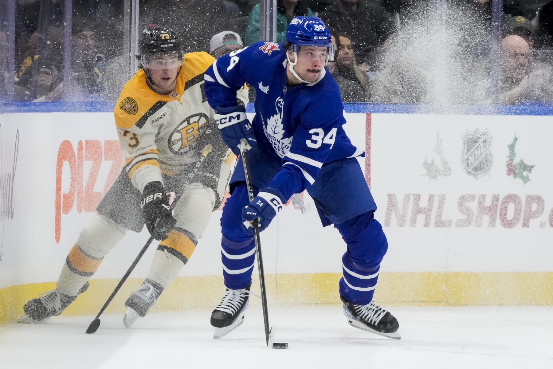 TORONTO, ON - DECEMBER 2: Auston Matthews #34 of the Toronto Maple Leafs plays the puck against Charlie McAvoy #73 of the Boston Bruins during the first period at the Scotiabank Arena on December 2, 2023 in Toronto, Ontario, Canada. (Photo by Andrew Lahodynskyj/NHLI via Getty Images)