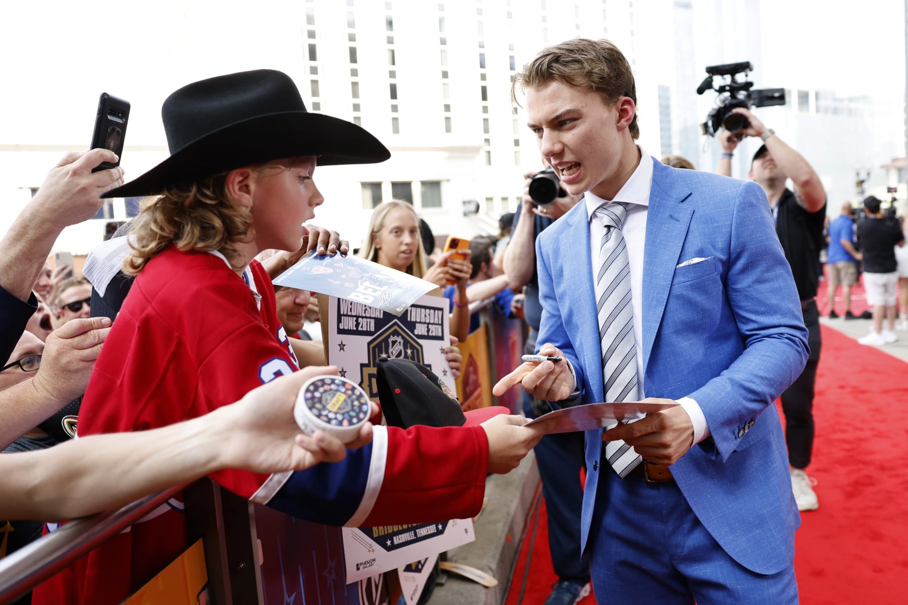 NASHVILLE, TENNESSEE - JUNE 28: Connor Bedard signs autographs for fans prior to the first round of the 2023 Upper Deck NHL Draft at Bridgestone Arena on June 28, 2023 in Nashville, Tennessee. (Photo by Jason Kempin/Getty Images)