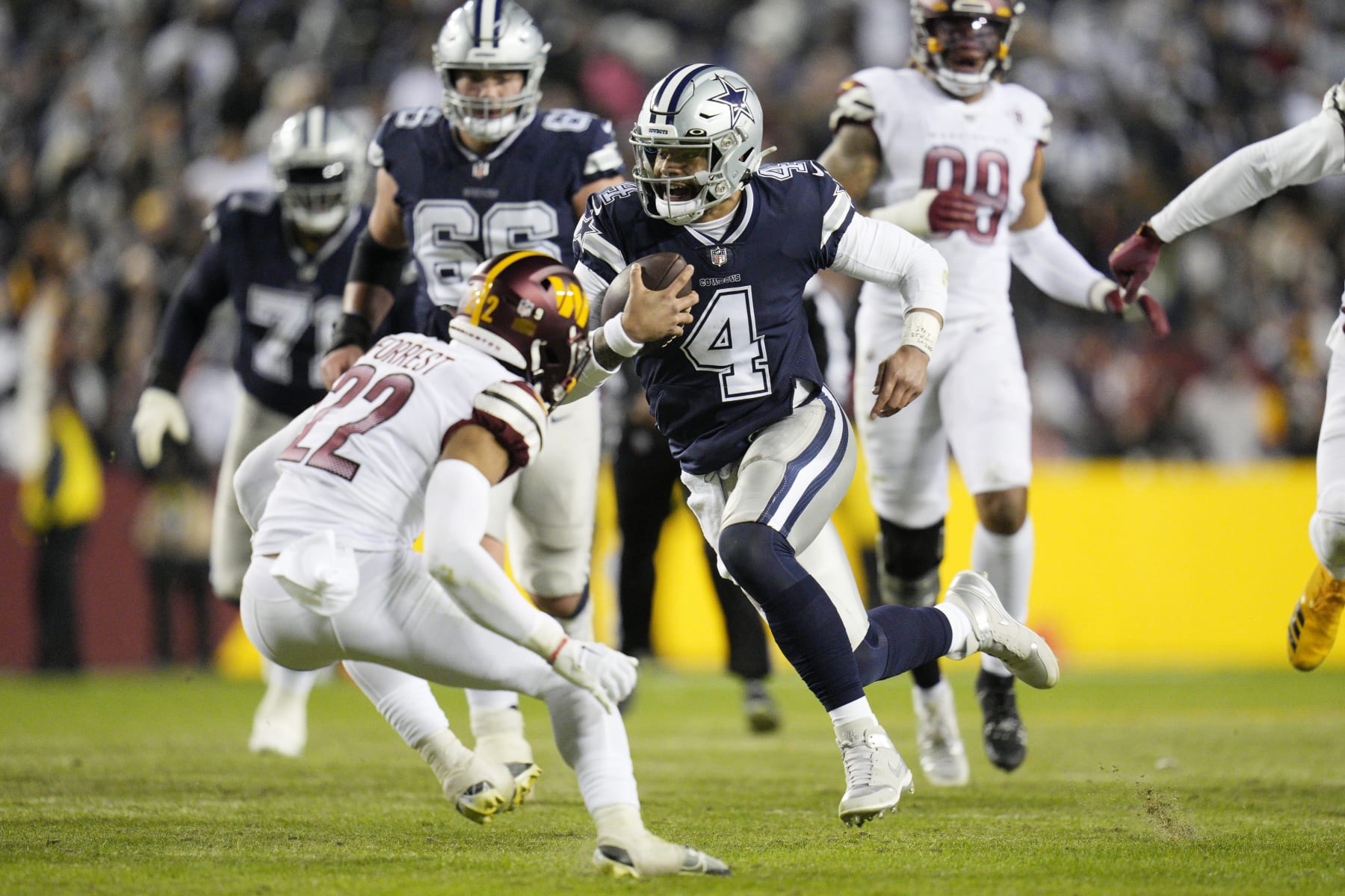 LANDOVER, MARYLAND - JANUARY 08: Dak Prescott #4 of the Dallas Cowboys runs with the ball during the first half of the game against the Washington Commanders at FedExField on January 08, 2023 in Landover, Maryland. (Photo by Jess Rapfogel/Getty Images)