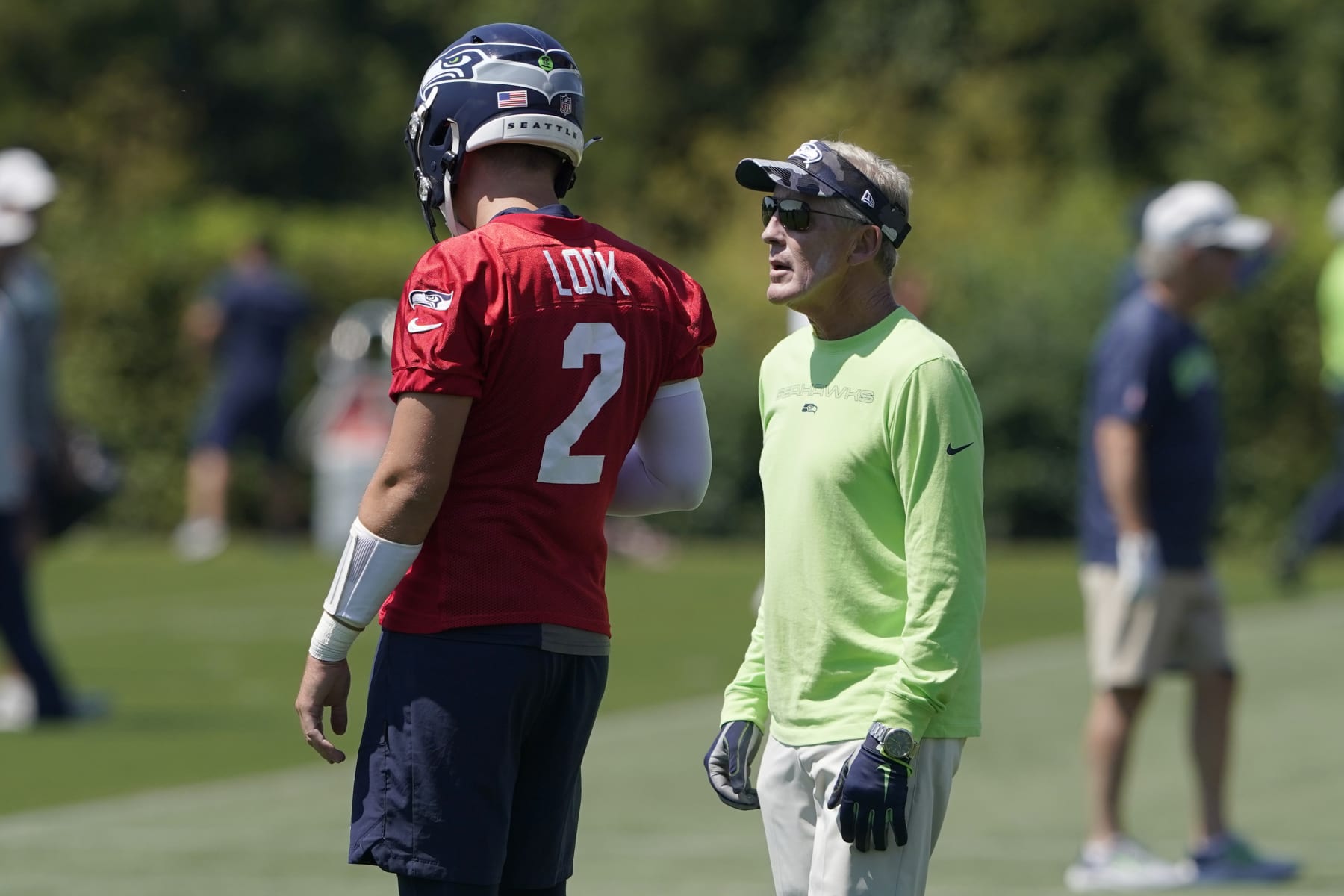 Seattle Seahawks coach Pete Carroll, right, talks with quarterback Drew Lock (2) during NFL football training camp Thursday, July 28, 2022, in Renton, Wash. (AP Photo/Ted S. Warren)