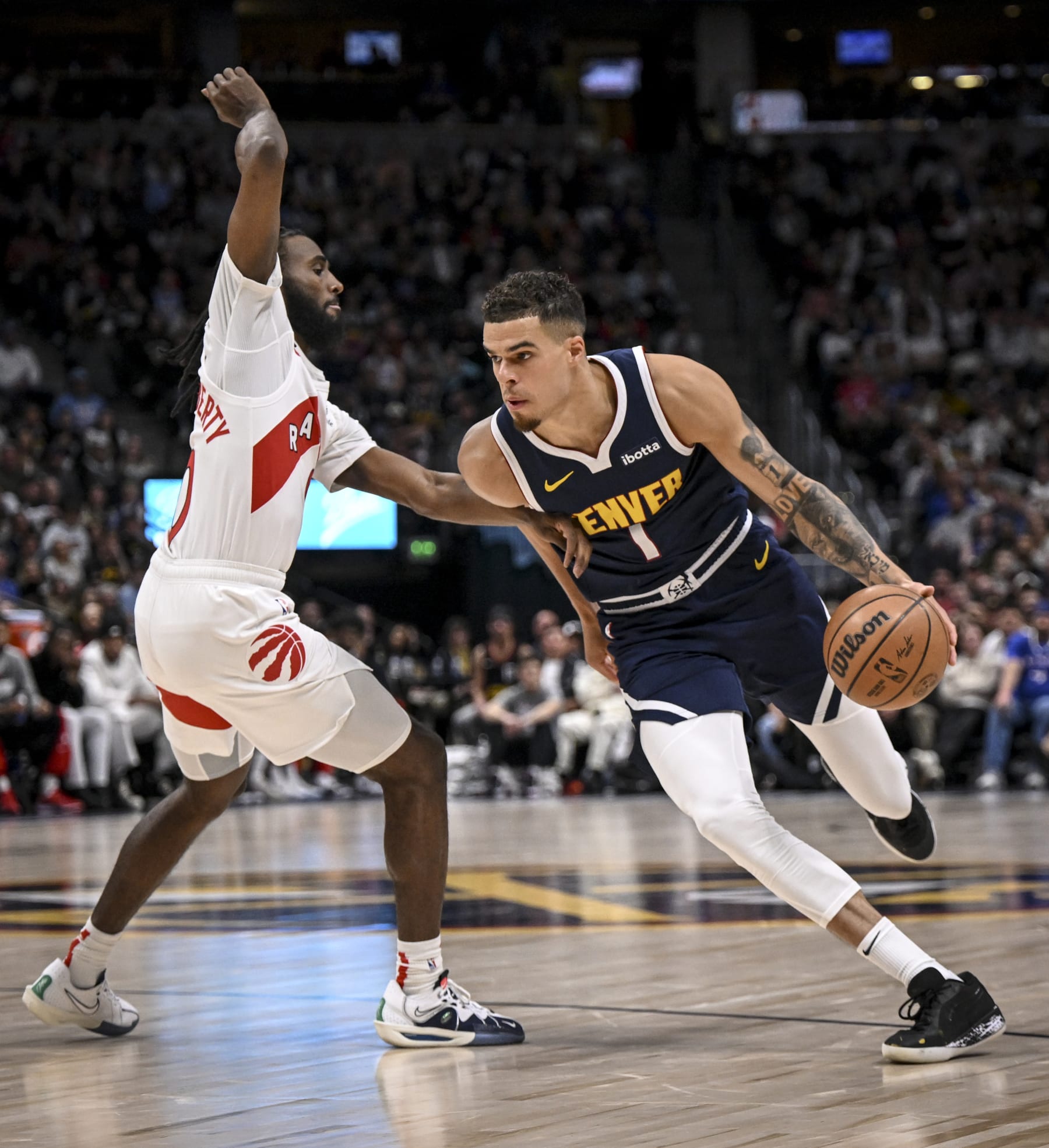 DENVER, CO - MARCH 11: Michael Porter Jr. (1) of the Denver Nuggets drives on Javon Freeman-Liberty (0) of the Toronto Raptors during the third quarter at Ball Arena in Denver on Monday, March 11, 2024. (Photo by AAron Ontiveroz/The Denver Post)
