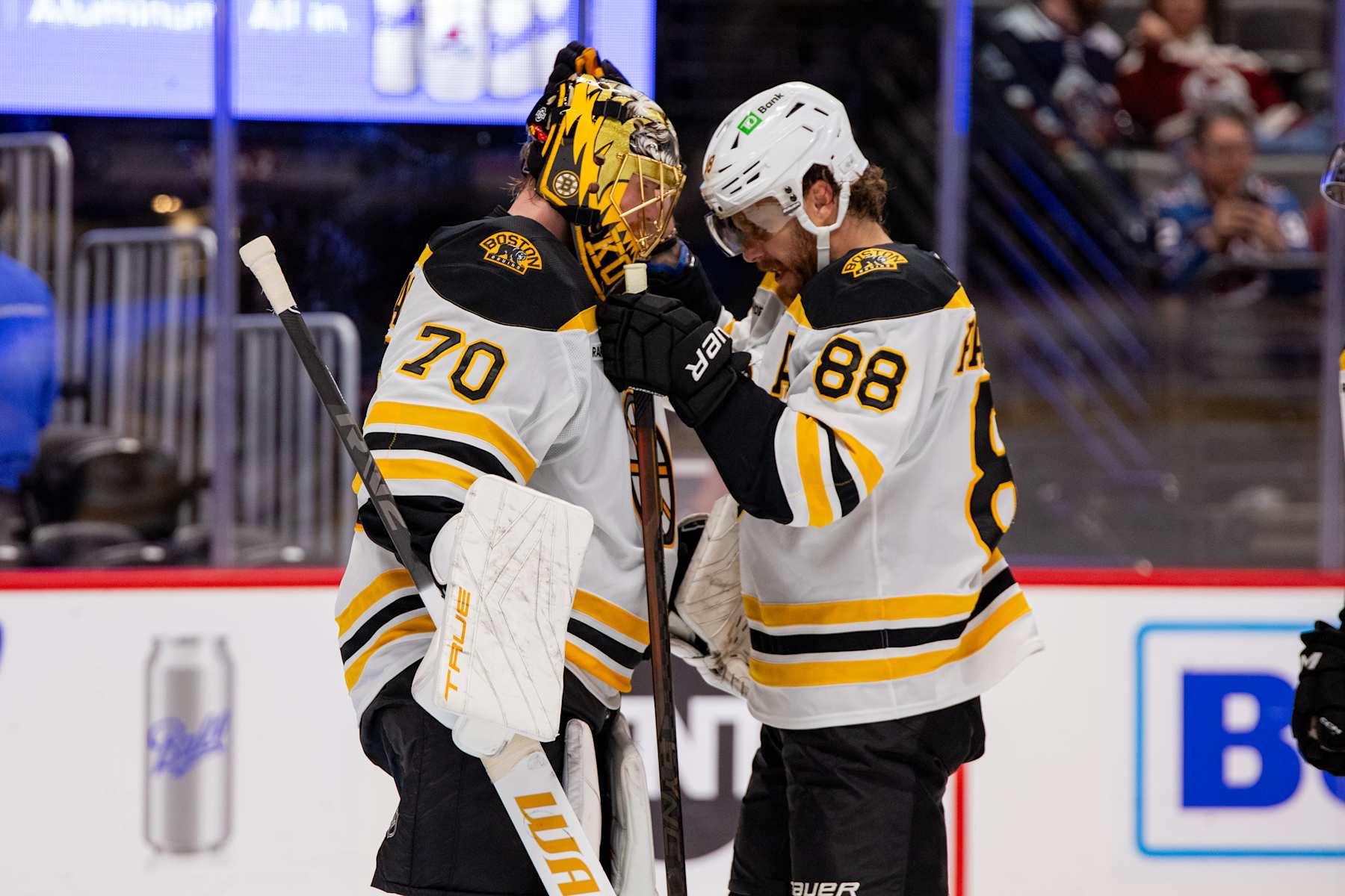 DENVER, COLORADO - OCTOBER 16: Joonas Korpisalo #70 and David Pastrnak #88 of the Boston Bruins hug after defeating the Colorado Avalanche 5-3 at Ball Arena on October 16, 2024 in Denver, Colorado. (Photo by Ashley Potts/NHLI via Getty Images)