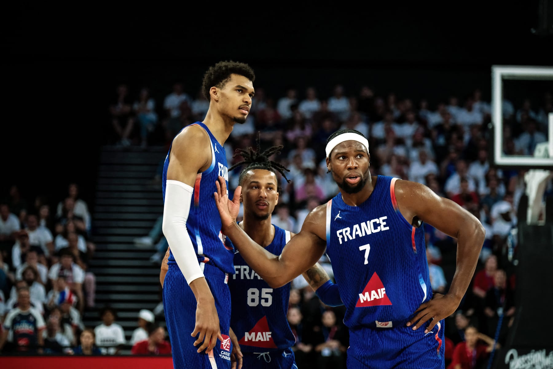 France's center Victor Wembanyama #32 (L), France's guard Matthew Strazel #85 (C) and France's forward Guerschon Yabusele #7 (R) react during the exhibition game between France and Serbia ahead of the Paris 2024 Olympic Games, in the LDLC Arena in Decines-Charpieu, eastern France, on July 12, 2024. (Photo by MAXIME GRUSS / AFP) (Photo by MAXIME GRUSS/AFP via Getty Images)