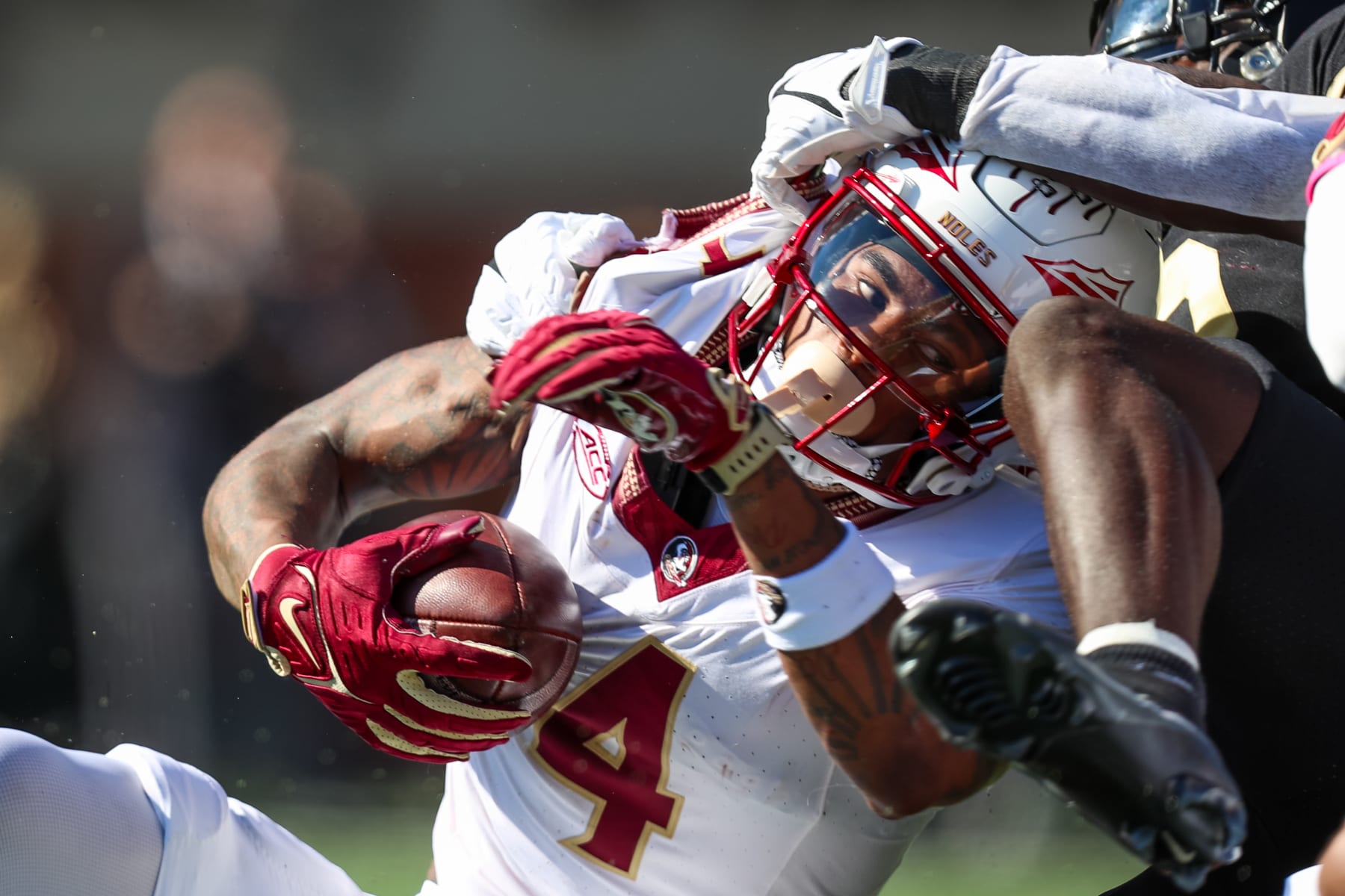 CHARLOTTE, NC - OCTOBER 28: Keon Coleman #4 of the Florida State Seminoles takes a hit as he runs the ball during a football game against the Wake Forest Demon Deacons at Allegacy Federal Credit Union Stadium in Winston-Salem, North Carolina on Oct 28, 2023. (Photo by David Jensen/Icon Sportswire via Getty Images)
