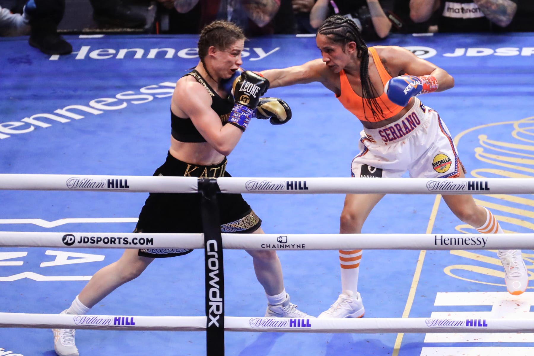 NEW YORK, NEW YORK - APRIL 30: Katie Taylor of Ireland (black trunks) gets hit by Amanda Serrano of Puerto Rico (white trunks) during their world lightweight championship fight. Taylor would win by split decision to remain the undisputed lightweight champion of the world and retain her WBA, WBC, IBF, WBO, and The Ring lightweight titles at Madison Square Garden on April 30, 2022 in New York, New York. Taylor and Serrano made history as the first female fighters to headline a boxing event in the venue's 140-year history. (Photo by J. Yim/Getty Images)