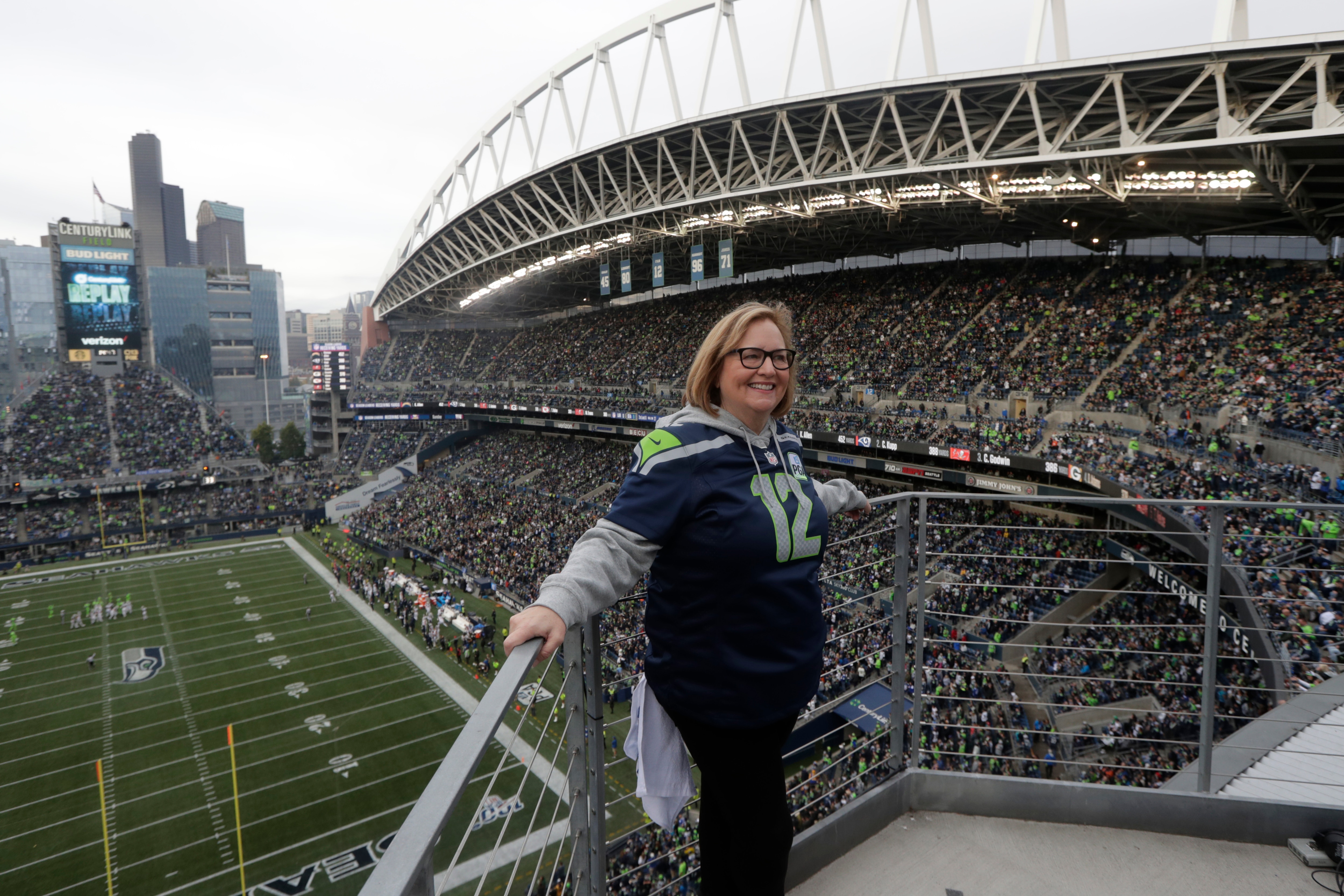 Seattle Seahawks owner Jody Allen stands on a balcony at CenturyLink Field after she raised the 12th man flag before the team's NFL football game against the Los Angeles Rams, Thursday, Oct. 3, 2019, in Seattle. (AP Photo/Stephen Brashear)