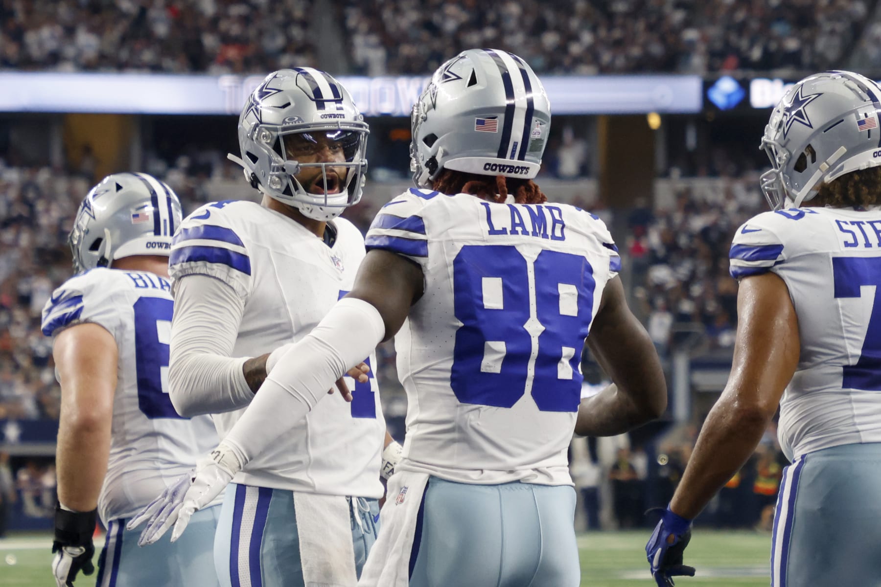 Dallas Cowboys quarterback Dak Prescott, center left, and wide receiver CeeDee Lamb (88) celebrate after Lamb caught a touhdown pass in the first half of an NFL football game against the New England Patriots in Arlington, Texas, Sunday, Oct. 1, 2023. (AP Photo/Michael Ainsworth)