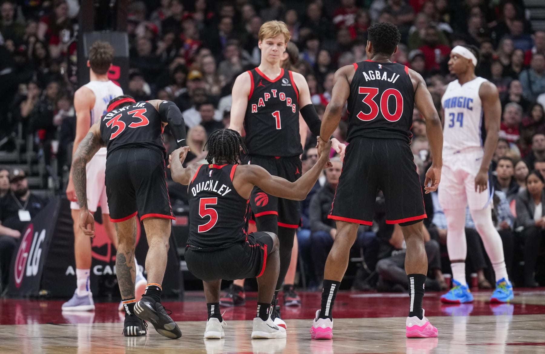 TORONTO, ON - MARCH 15: Immanuel Quickley #5 of the Toronto Raptors is picked up by teammates Gary Trent Jr. #33, Gradey Dick #1, Gradey Dick #1 and Ochai Agbaji #30 against the Orlando Magic during the first half of their basketball game at the Scotiabank Arena on March 15, 2024 in Toronto, Ontario, Canada. NOTE TO USER: User expressly acknowledges and agrees that, by downloading and/or using this Photograph, user is consenting to the terms and conditions of the Getty Images License Agreement. (Photo by Mark Blinch/Getty Images)