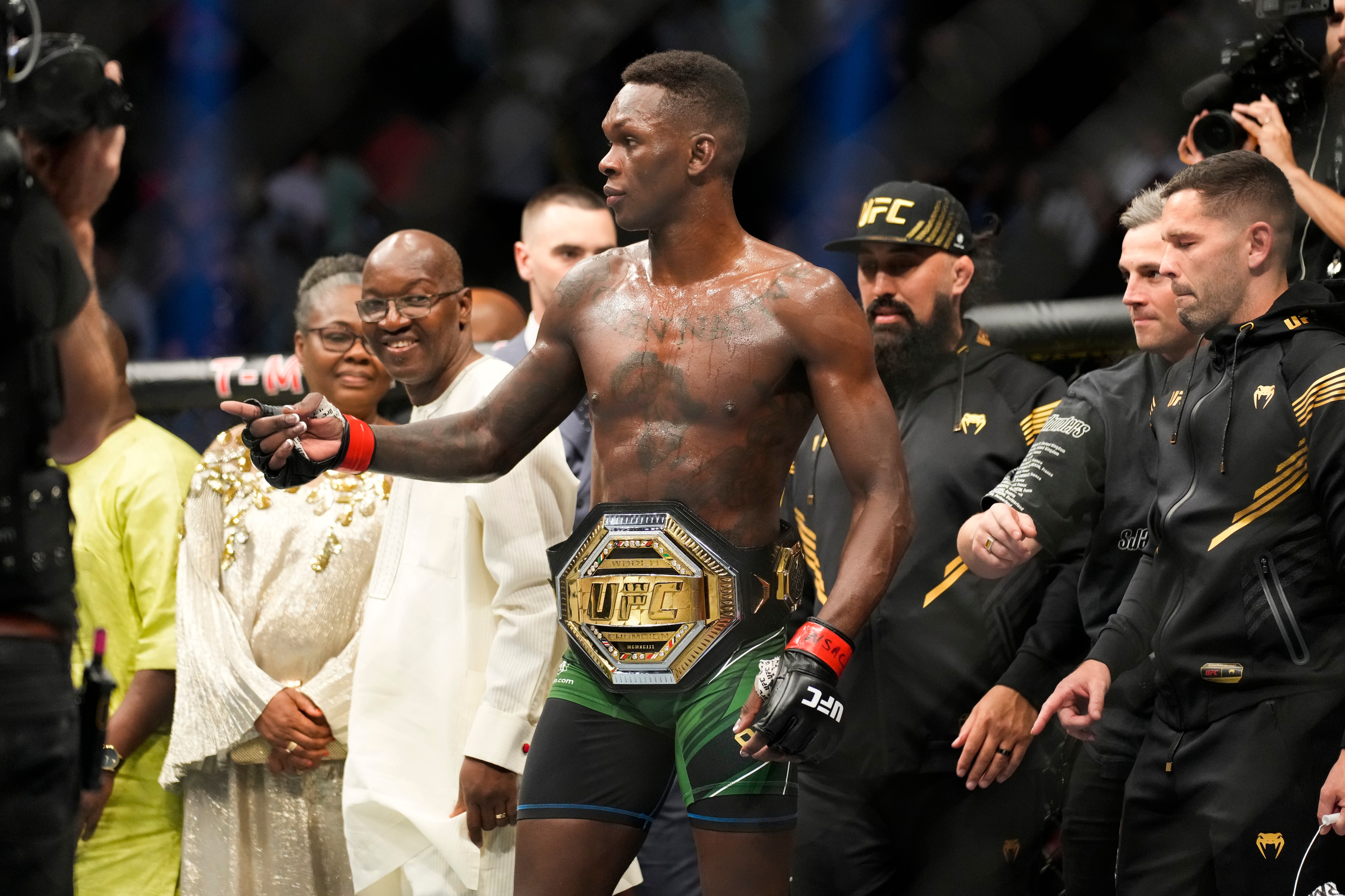 Israel Adesanya, center, reacts after winning a middleweight title bout against Jared Cannonier during the UFC 276 mixed martial arts event Saturday, July 2, 2022, in Las Vegas. (AP Photo/John Locher)