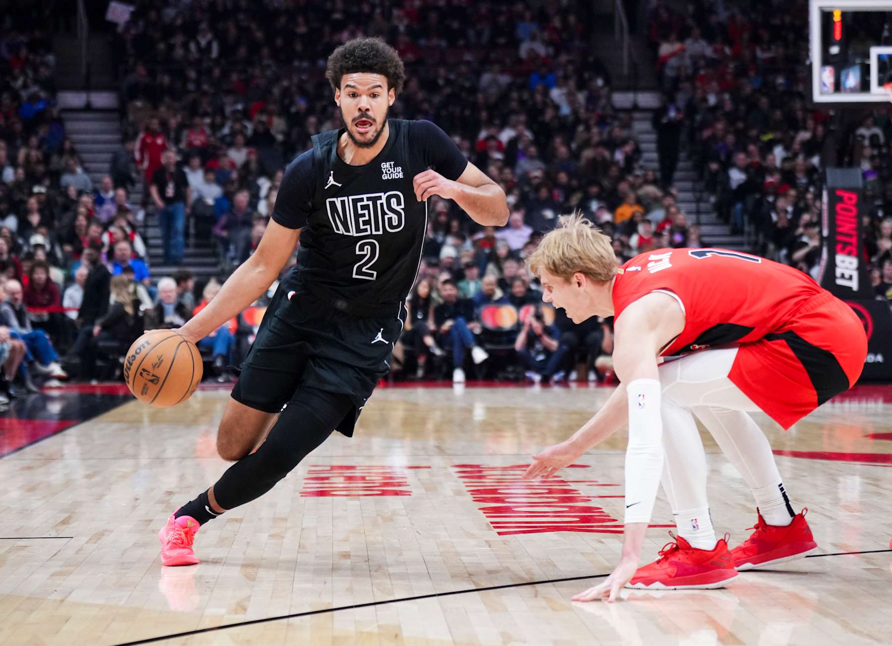 TORONTO, ON - JANUARY 1: Cameron Johnson #2 of the Brooklyn Nets dribbles against Gradey Dick #1 of the Toronto Raptors during the first half of their basketball game at the Scotiabank Arena on January 1, 2025 in Toronto, Ontario, Canada. NOTE TO USER: User expressly acknowledges and agrees that, by downloading and/or using this Photograph, user is consenting to the terms and conditions of the Getty Images License Agreement. (Photo by Mark Blinch/Getty Images)