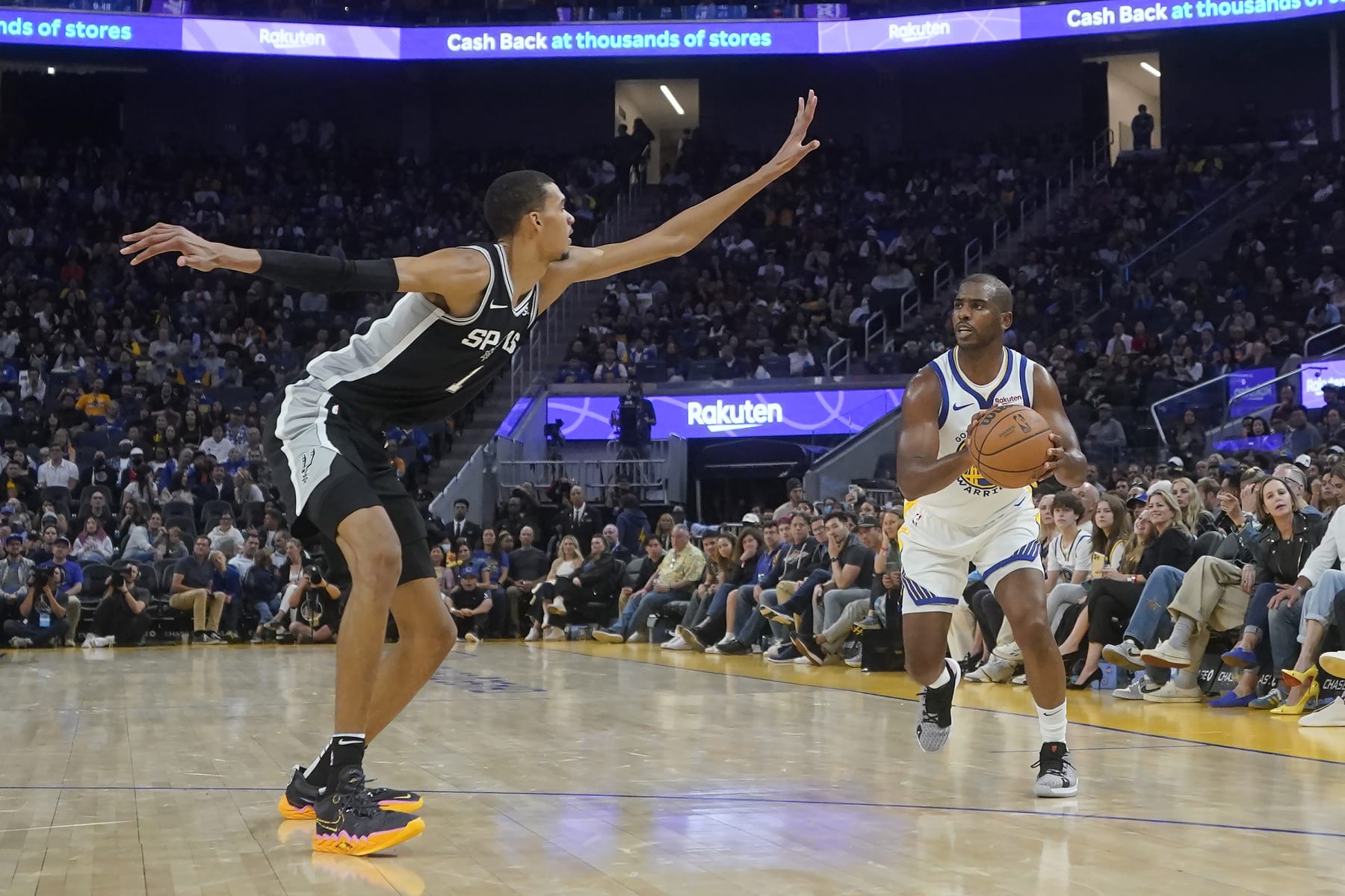 Golden State Warriors guard Chris Paul, right, is defended by San Antonio Spurs center Victor Wembanyama (1) during an NBA preseason basketball game in San Francisco, Friday, Oct. 20, 2023. (AP Photo/Jeff Chiu)