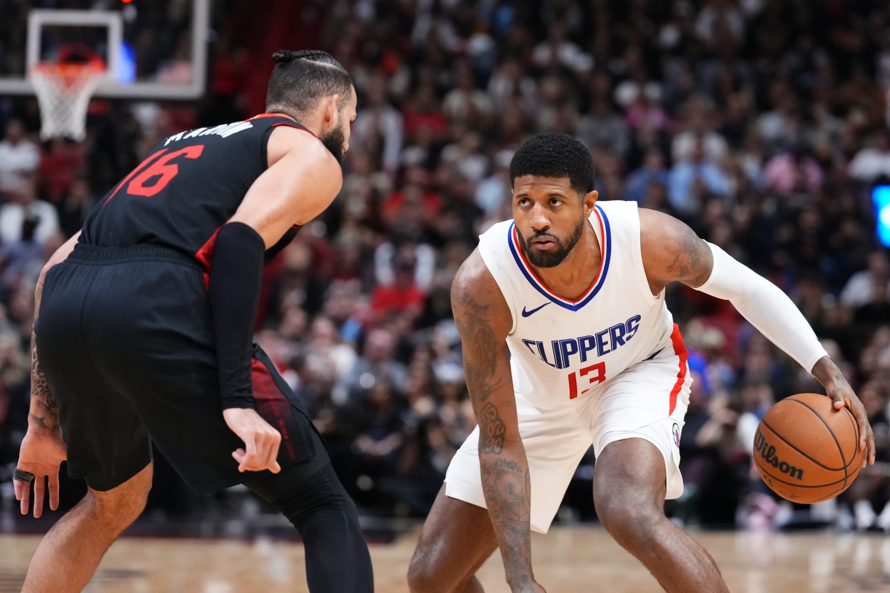 MIAMI, FLORIDA - FEBRUARY 04: Paul George #13 of the LA Clippers dribbles the ball against Caleb Martin #16 of the Miami Heat during the fourth quarter at Kaseya Center on February 04, 2024 in Miami, Florida. User expressly acknowledges and agrees that, by downloading and or using this photograph, User is consenting to the terms and conditions of the Getty Images License Agreement. (Photo by Rich Storry/Getty Images)