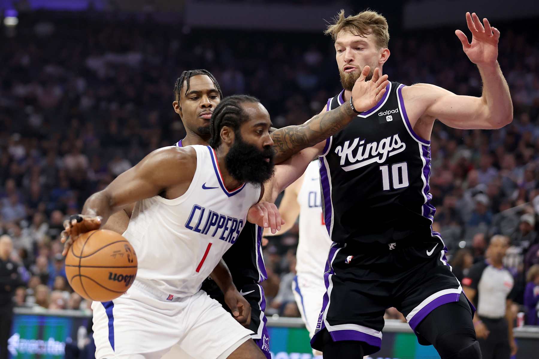 SACRAMENTO, CALIFORNIA - APRIL 02: James Harden #1 of the LA Clippers is guarded by Davion Mitchell #15 and Domantas Sabonis #10 of the Sacramento Kings in the first half at Golden 1 Center on April 02, 2024 in Sacramento, California. NOTE TO USER: User expressly acknowledges and agrees that, by downloading and or using this photograph, User is consenting to the terms and conditions of the Getty Images License Agreement.  (Photo by Ezra Shaw/Getty Images)