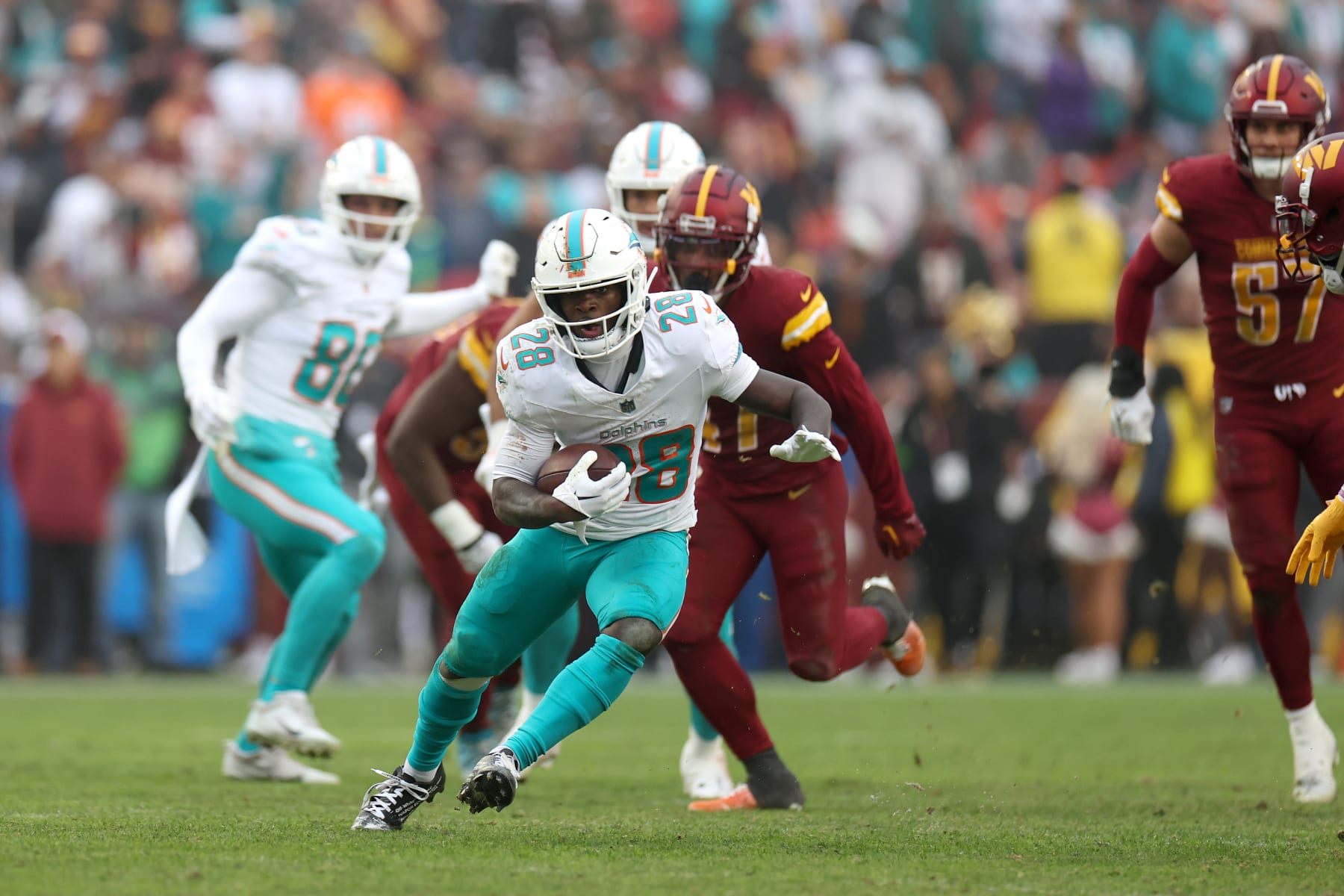 LANDOVER, MARYLAND - DECEMBER 03: Running back De'Von Achane #28 of the Miami Dolphins rushes the ball against the Washington Commanders in the second half at FedExField on December 03, 2023 in Landover, Maryland. (Photo by Rob Carr/Getty Images)