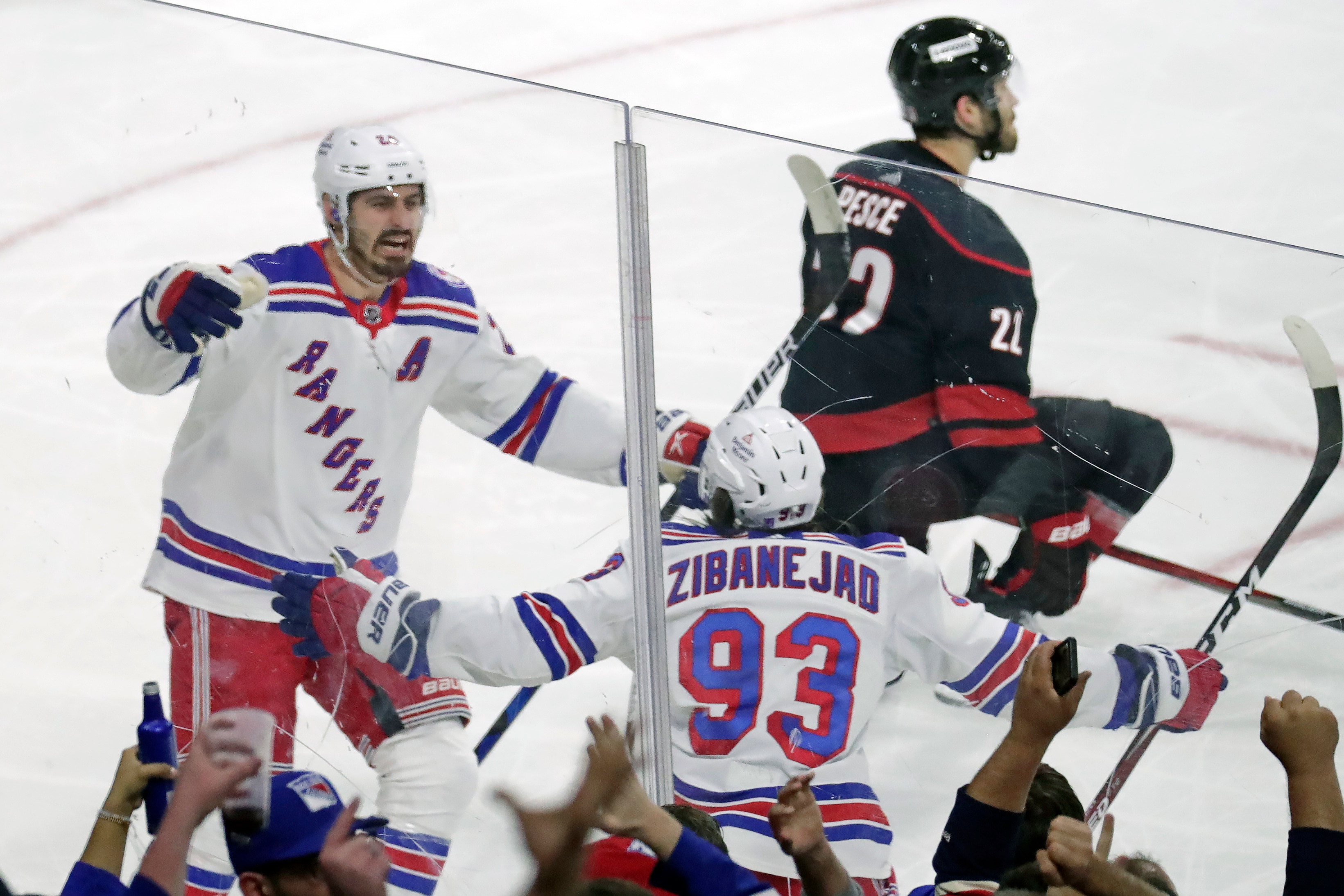 New York Rangers left wing Chris Kreider (20) celebrates his goal with center Mika Zibanejad (93) during the first period of Game 7 of an NHL hockey Stanley Cup second-round playoff series against the Carolina Hurricanes, Monday, May 30, 2022, in Raleigh, N.C. Hurricanes defenseman Brett Pesce (22)looks on. (AP Photo/Chris Seward)