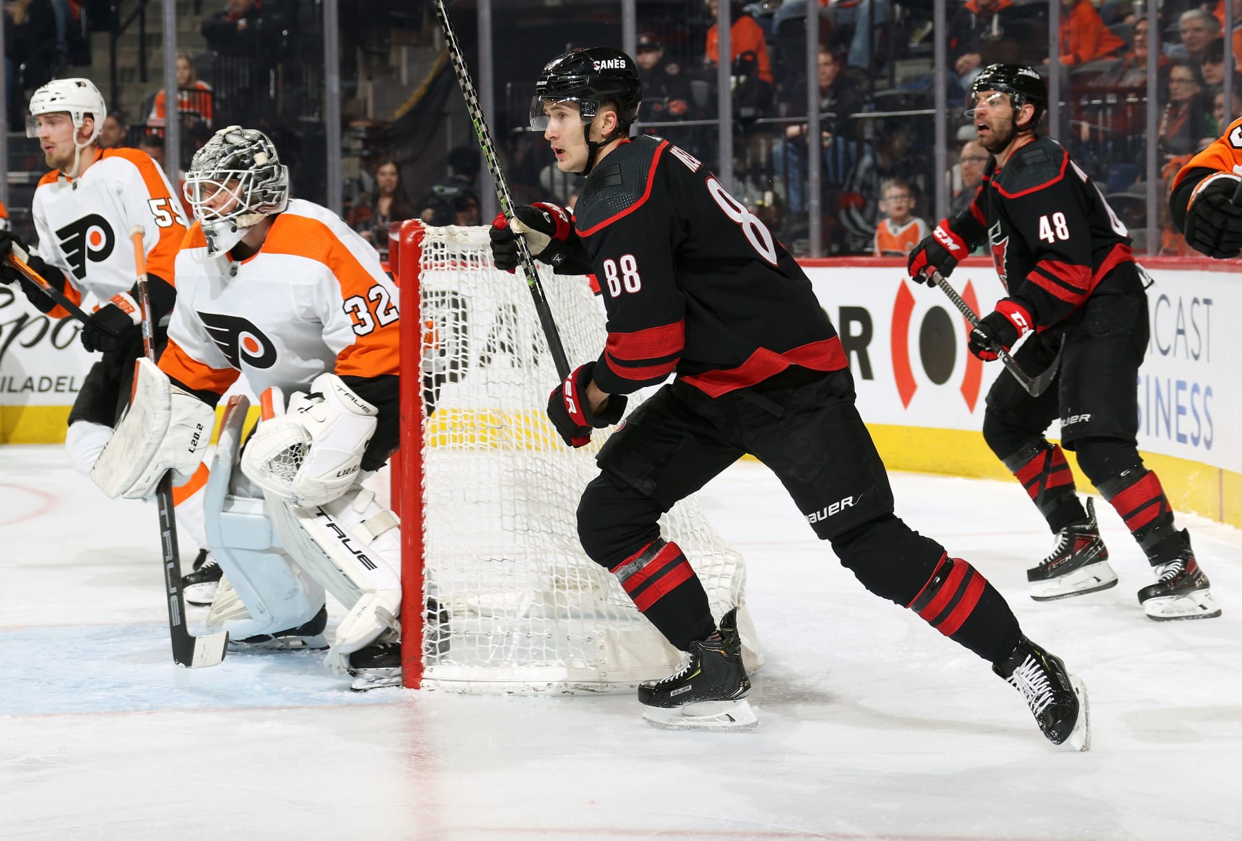 PHILADELPHIA, PENNSYLVANIA - MARCH 18:  Martin Necas #88 and Jordan Martinook #48 of the Carolina Hurricanes positioned around the net against Felix Standstrom #32 and Rasmus Ristolainen #55 of the Philadelphia Flyers at the Wells Fargo Center on March 18, 2023 in Philadelphia, Pennsylvania.  (Photo by Len Redkoles/NHLI via Getty Images)