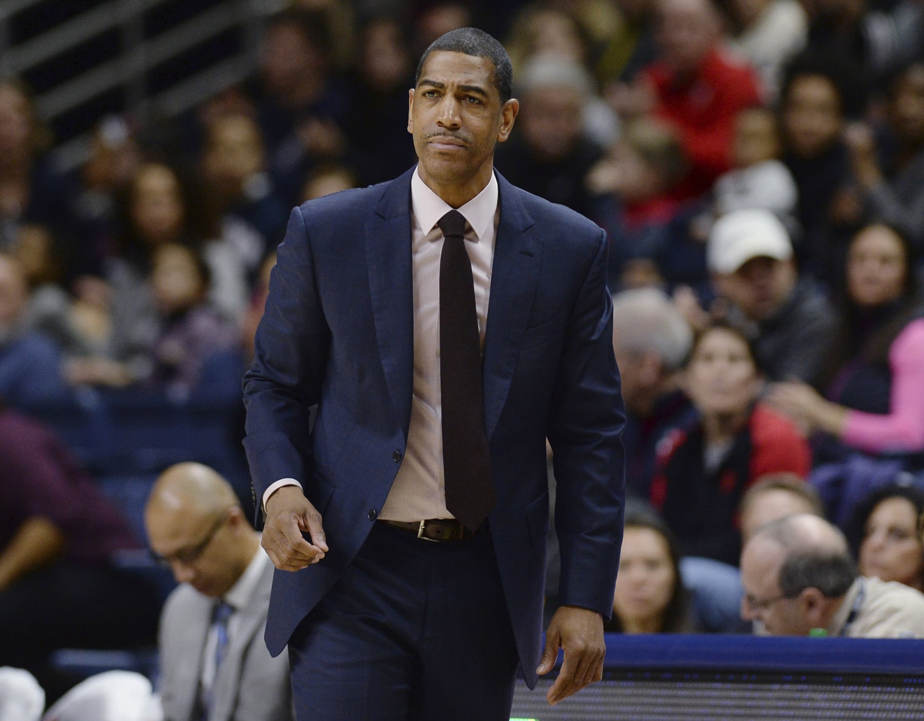FILE - In this Feb. 25, 2018, file photo, then-Connecticut coach Kevin Ollie watches during the first half the team's NCAA college basketball game in Storrs, Conn. Former Connecticut head coach Kevin Ollie has been brought on board in a leadership role for a new basketball league designed to offer elite high school players another pathway to the pros. Ollie will serve as coach and director of player development for Overtime Elite, which markets itself to 16-to-18 year old players with guarantees of academic education and a six-figure salary. (AP Photo/Jessica Hill, File) FILE - In this Feb. 25, 2018, file photo, then-Connecticut coach Kevin Ollie watches during the first half the team's NCAA college basketball game in Storrs, Conn. Former Connecticut head coach Kevin Ollie has been brought on board in a leadership role for a new basketball league designed to offer elite high school players another pathway to the pros. Ollie will serve as coach and director of player development for Overtime Elite, which markets itself to 16-to-18 year old players with guarantees of academic education and a six-figure salary. (AP Photo/Jessica Hill, File)