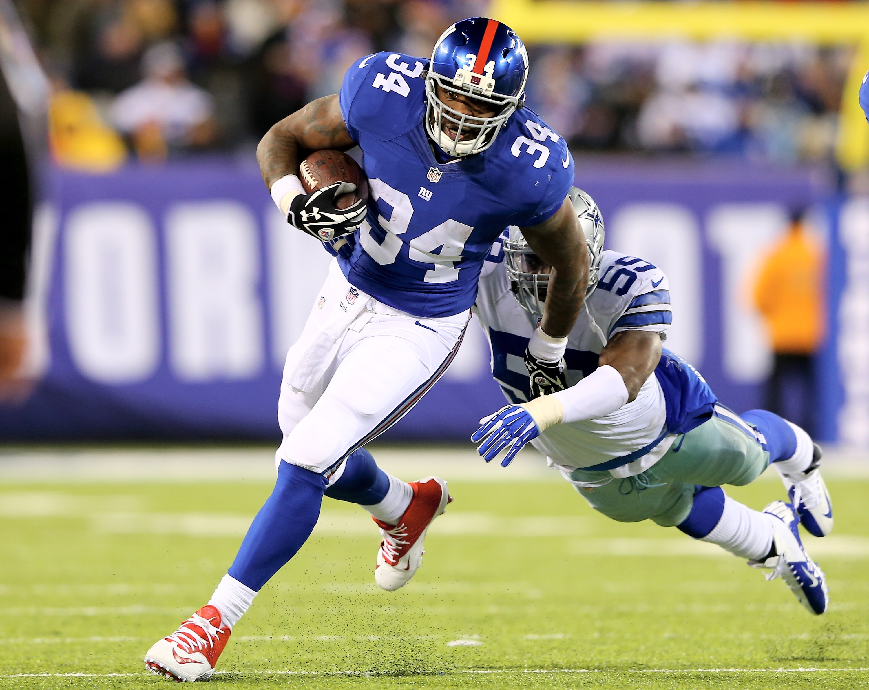 EAST RUTHERFORD, NJ - NOVEMBER 24:  Brandon Jacobs #34 of the New York Giants carries the ball as Ernie Sims #59 of the Dallas Cowboys tries to make the tackle at MetLife Stadium on November 24, 2013 in East Rutherford, New Jersey.The Dallas Cowboys defeated the New York Giants 24-21.  (Photo by Elsa/Getty Images)
