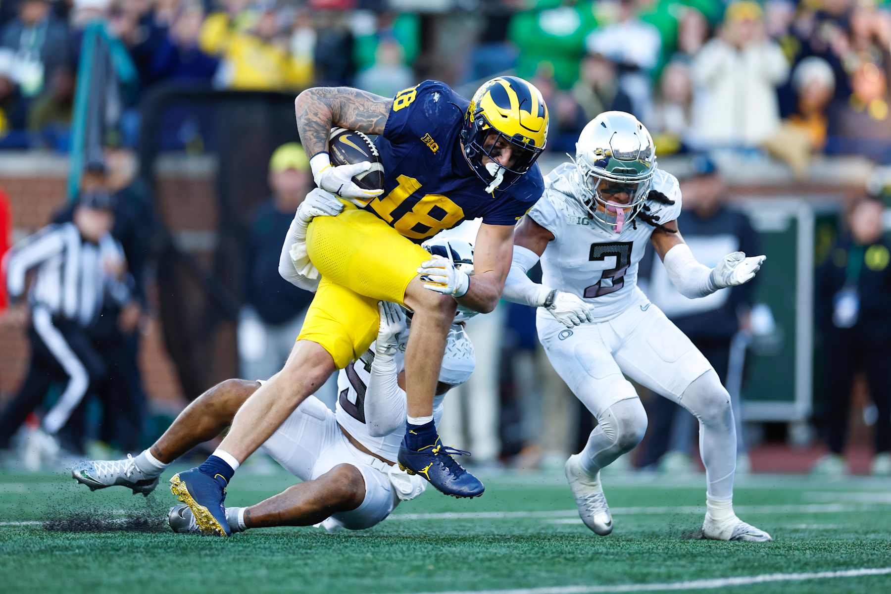 ANN ARBOR, MICHIGAN - NOVEMBER 2: Colston Loveland #18 of the Michigan Wolverines runs after the catch in front of Kobe Savage #5 of the Oregon Ducks and Brandon Johnson #3 during the second half at Michigan Stadium on November 2, 2024 in Ann Arbor, Michigan. (Photo by Brandon Sloter/Image Of Sport/Getty Images)
