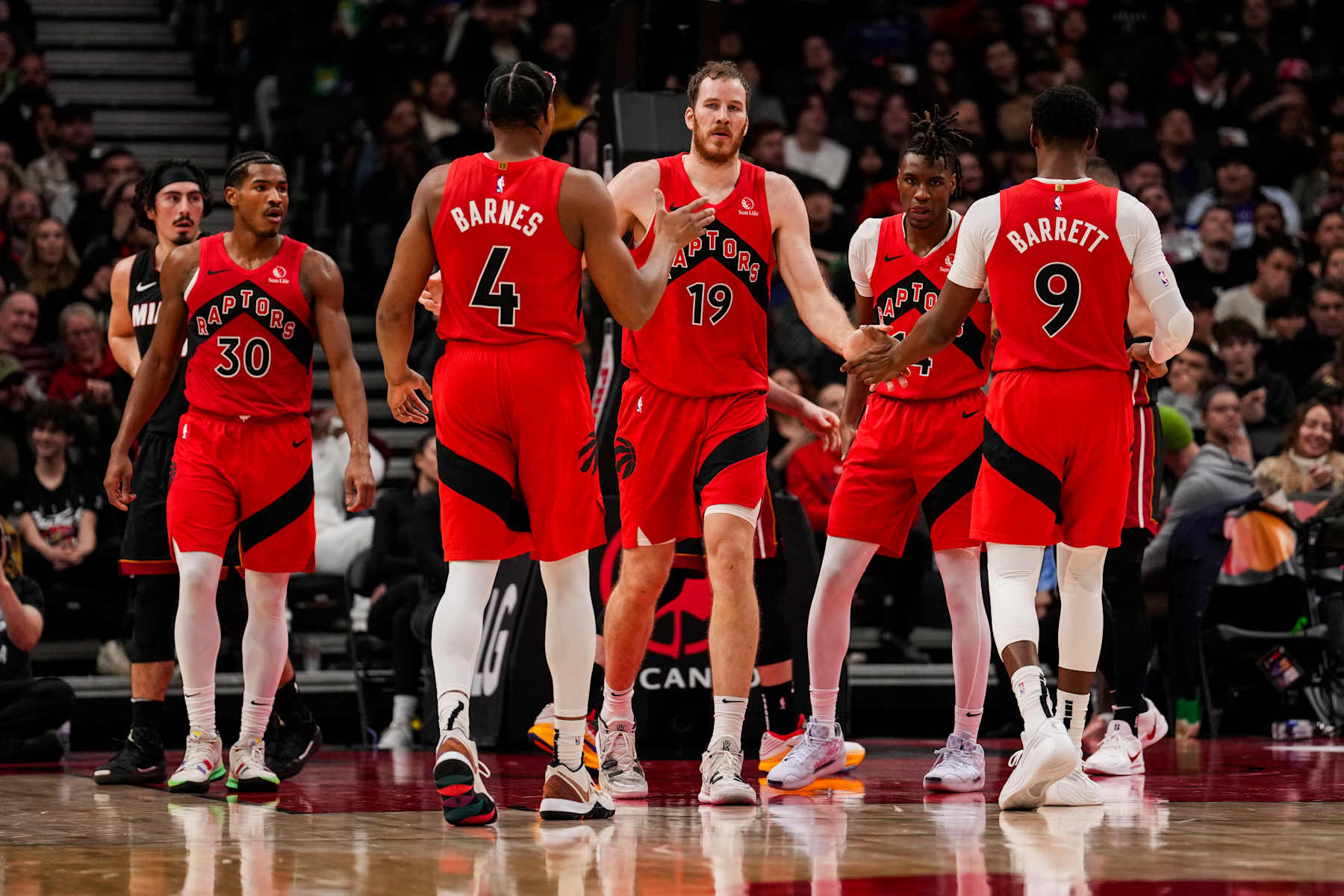 TORONTO, ON - DECEMBER 1: Jakob Poeltl #19 of the Toronto Raptors celebrates with teammates Scottie Barnes #4 and RJ Barrett #9 against the Miami Heat at Scotiabank Arena on December 1, 2024 in Toronto, Ontario, Canada. NOTE TO USER: User expressly acknowledges and agrees that, by downloading and/or using this Photograph, user is consenting to the terms and conditions of the Getty Images License Agreement. (Photo by Andrew Lahodynskyj/Getty Images)