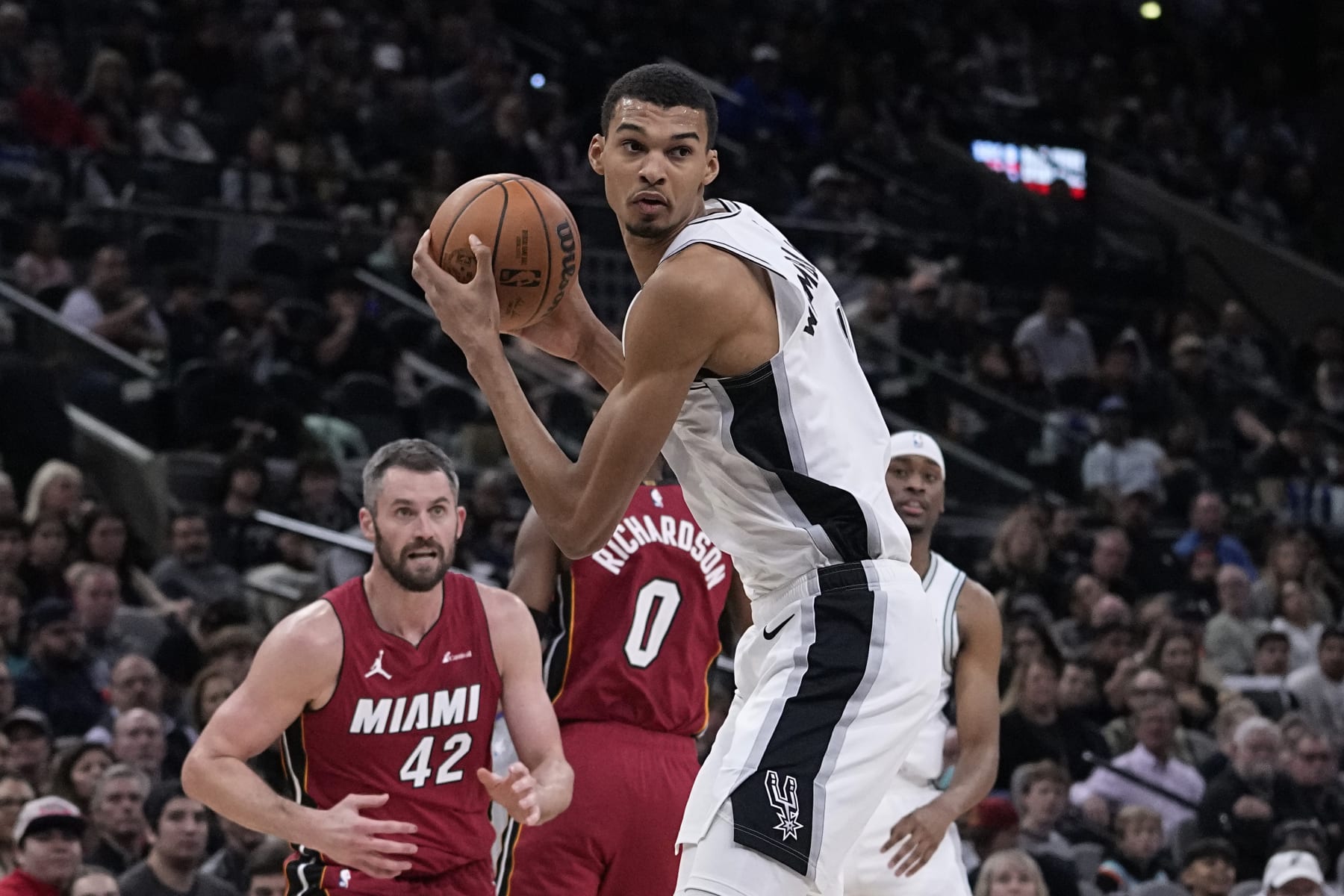 San Antonio Spurs center Victor Wembanyama (1) grabs a pass in front of Miami Heat forward Kevin Love (42) during the second half of an NBA basketball game in San Antonio, Sunday, Nov. 12, 2023. (AP Photo/Eric Gay)