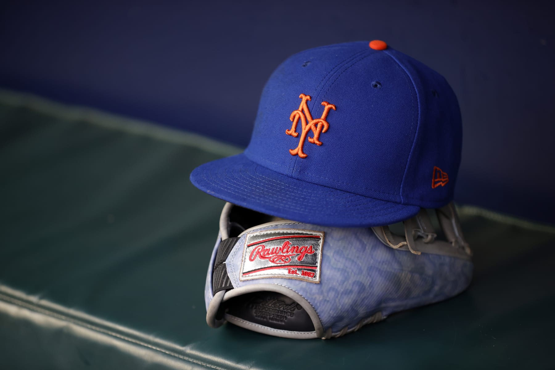 ATLANTA, GEORGIA - AUGUST 22: A New York Mets hat and Rawlings baseball glove and sit in the dugout before a game against the Atlanta Braves at Truist Park on August 22, 2023 in Atlanta, Georgia. (Photo by Alex Slitz/Getty Images)
