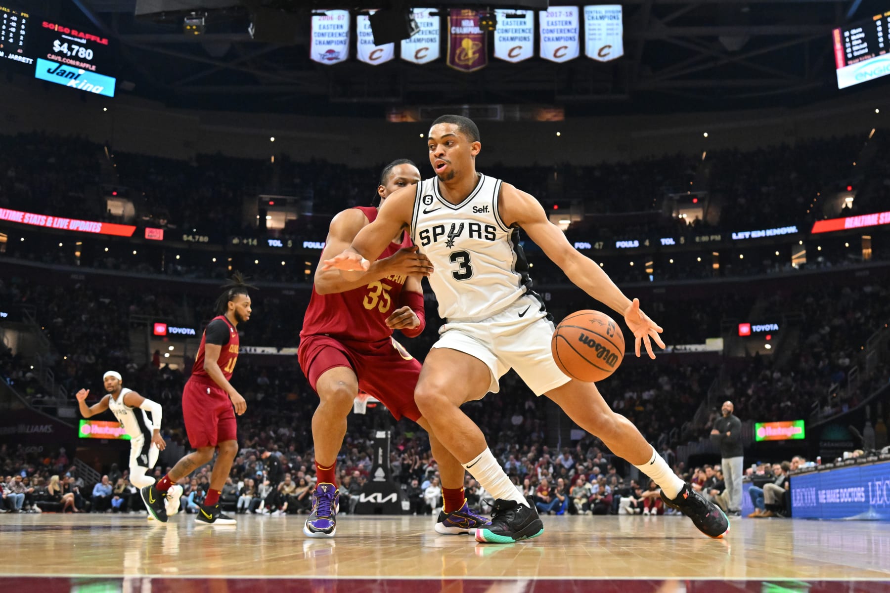 CLEVELAND, OHIO - FEBRUARY 13: Keldon Johnson #3 of the San Antonio Spurs drives around Isaac Okoro #35 of the Cleveland Cavaliers during the second quarter at Rocket Mortgage Fieldhouse on February 13, 2023 in Cleveland, Ohio. NOTE TO USER: User expressly acknowledges and agrees that, by downloading and or using this photograph, User is consenting to the terms and conditions of the Getty Images License Agreement. (Photo by Jason Miller/Getty Images)