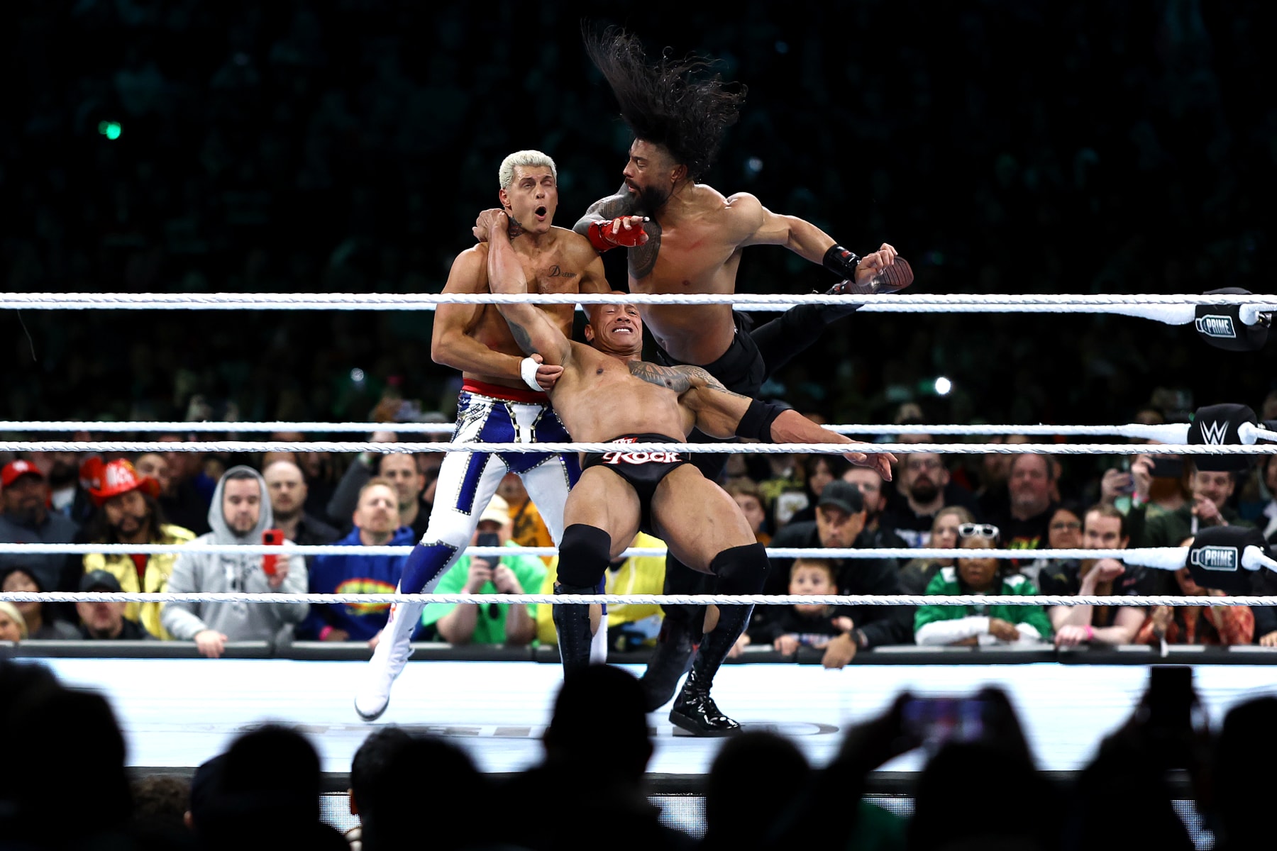 PHILADELPHIA, PENNSYLVANIA - APRIL 06: Cody Rhodes is hit by Dwayne "The Rock" Johnson and Roman Reigns during a fight during Night One of WrestleMania 40 at Lincoln Financial Field on April 06, 2024 in Philadelphia, Pennsylvania.  (Photo by Tim Nwachukwu/Getty Images)