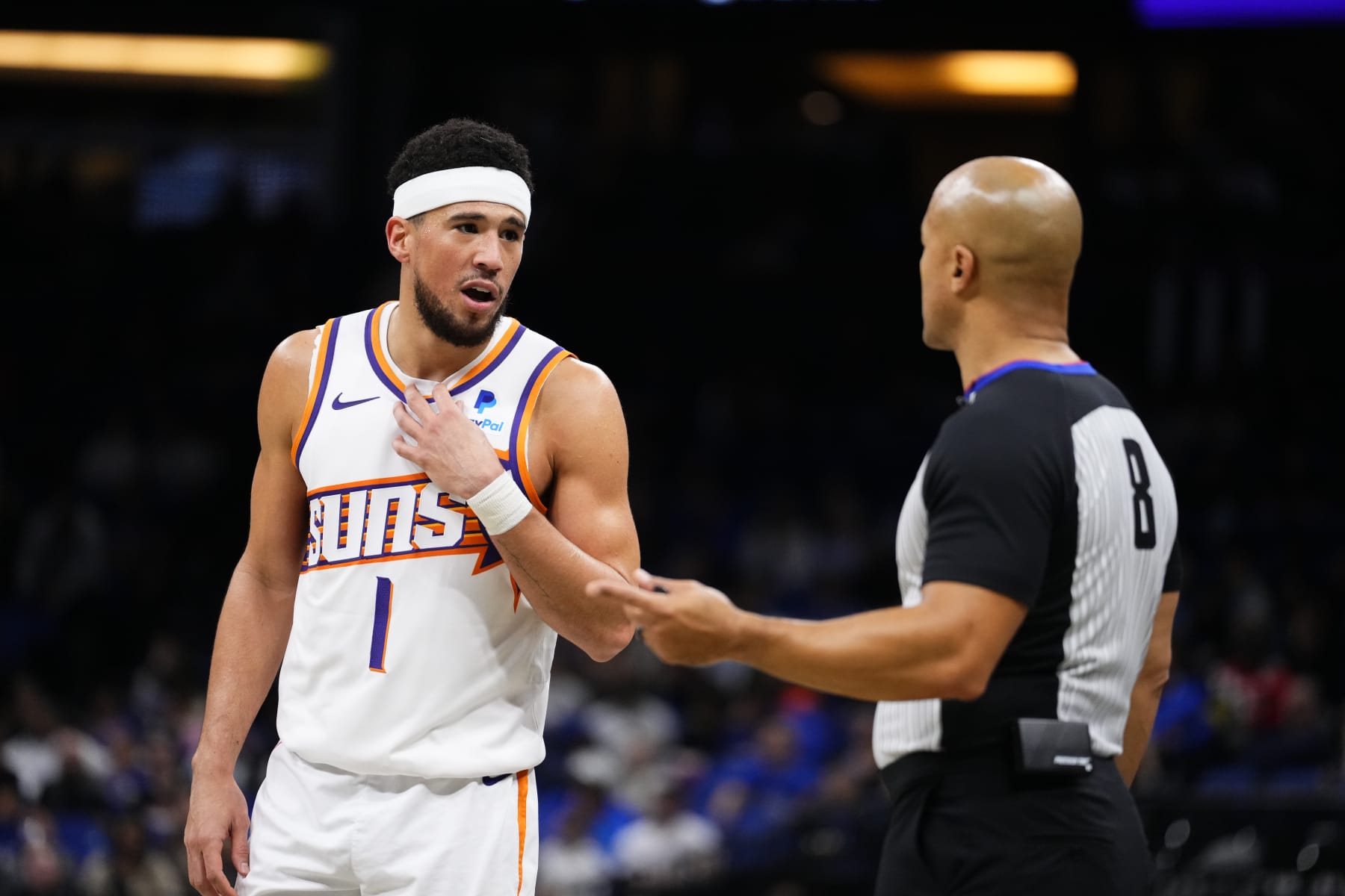 ORLANDO, FLORIDA - JANUARY 28: Devin Booker #1 of the Phoenix Suns speaks to referee Marc Davis #8 during a game against the Orlando Magic at Kia Center on January 28, 2024 in Orlando, Florida. NOTE TO USER: User expressly acknowledges and agrees that, by downloading and or using this photograph, User is consenting to the terms and conditions of the Getty Images License Agreement. (Photo by Rich Storry/Getty Images)