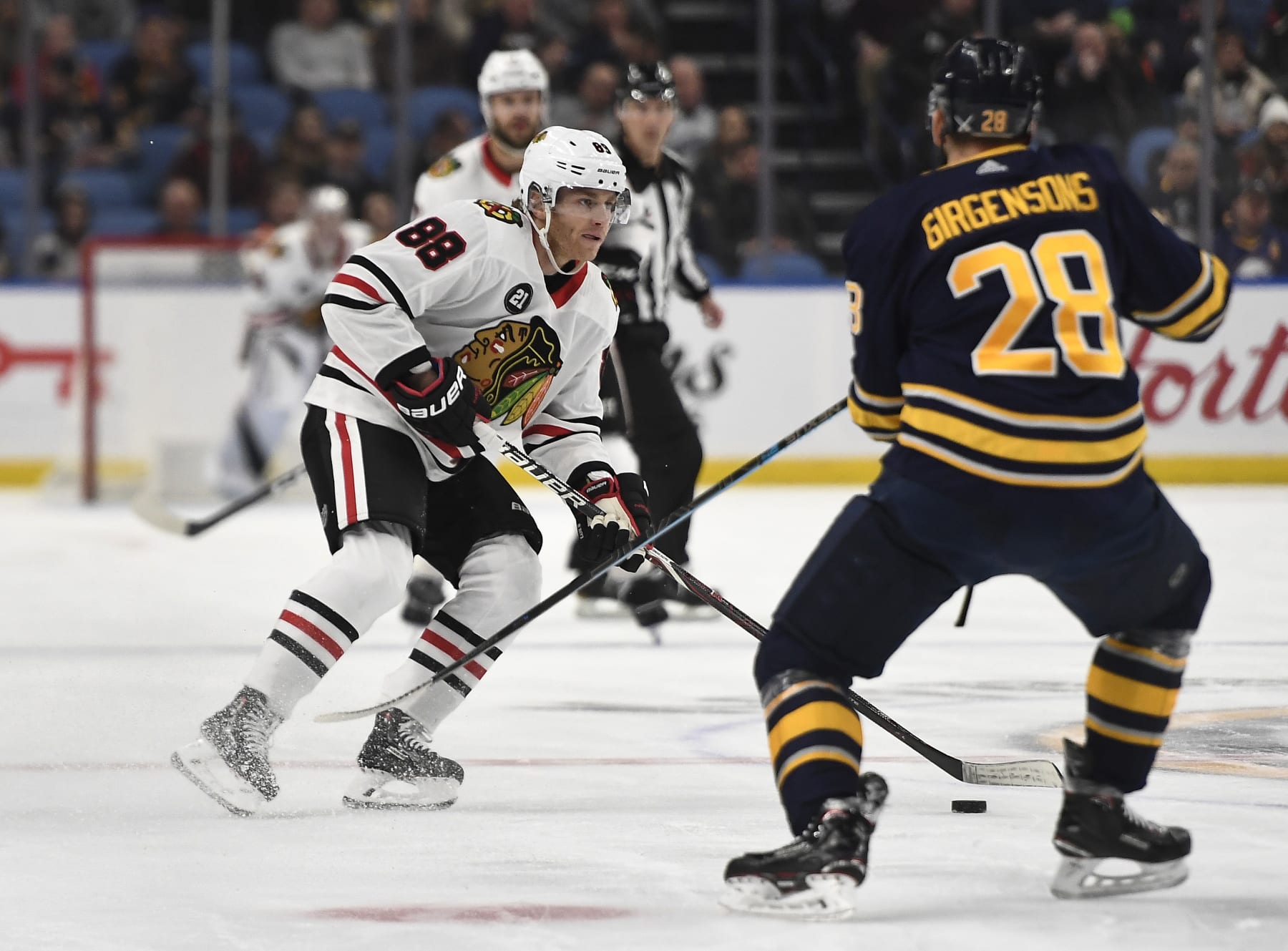 Chicago Blackhawks right wing Patrick Kane (88) skates with the puck in front of Buffalo Sabres' Zemgus Girgensons during the first period of an NHL hockey game in Buffalo, N.Y., Friday, Feb. 1, 2019. Chicago won 7-3. (AP Photo/Adrian Kraus)