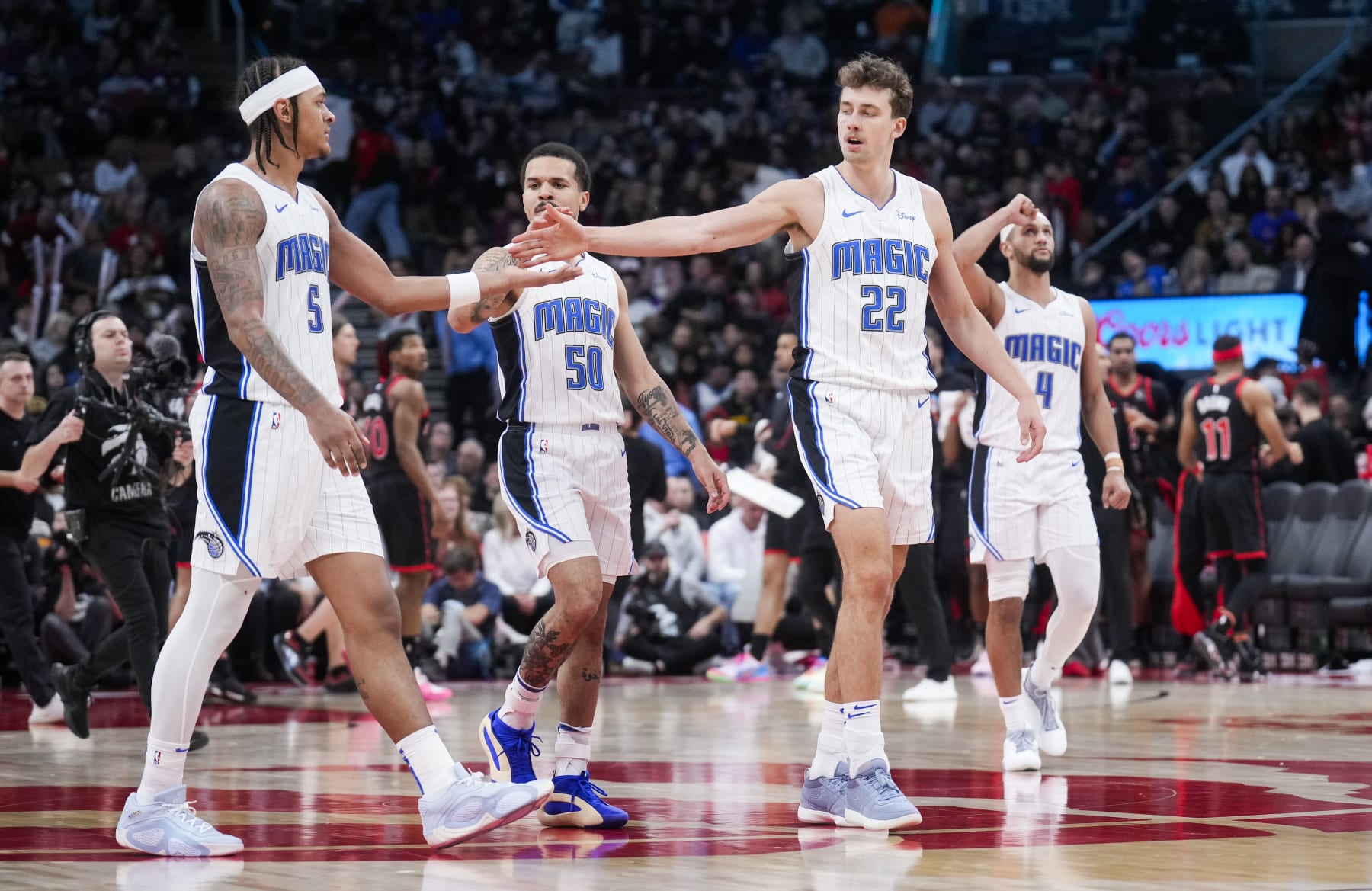 TORONTO, ON - MARCH 15: Paolo Banchero #5, Cole Anthony #50, Franz Wagner #22 and Jalen Suggs #4 of the Orlando Magic celebrate against the Toronto Raptors during the second half of their basketball game at the Scotiabank Arena on March 15, 2024 in Toronto, Ontario, Canada. NOTE TO USER: User expressly acknowledges and agrees that, by downloading and/or using this Photograph, user is consenting to the terms and conditions of the Getty Images License Agreement. (Photo by Mark Blinch/Getty Images)