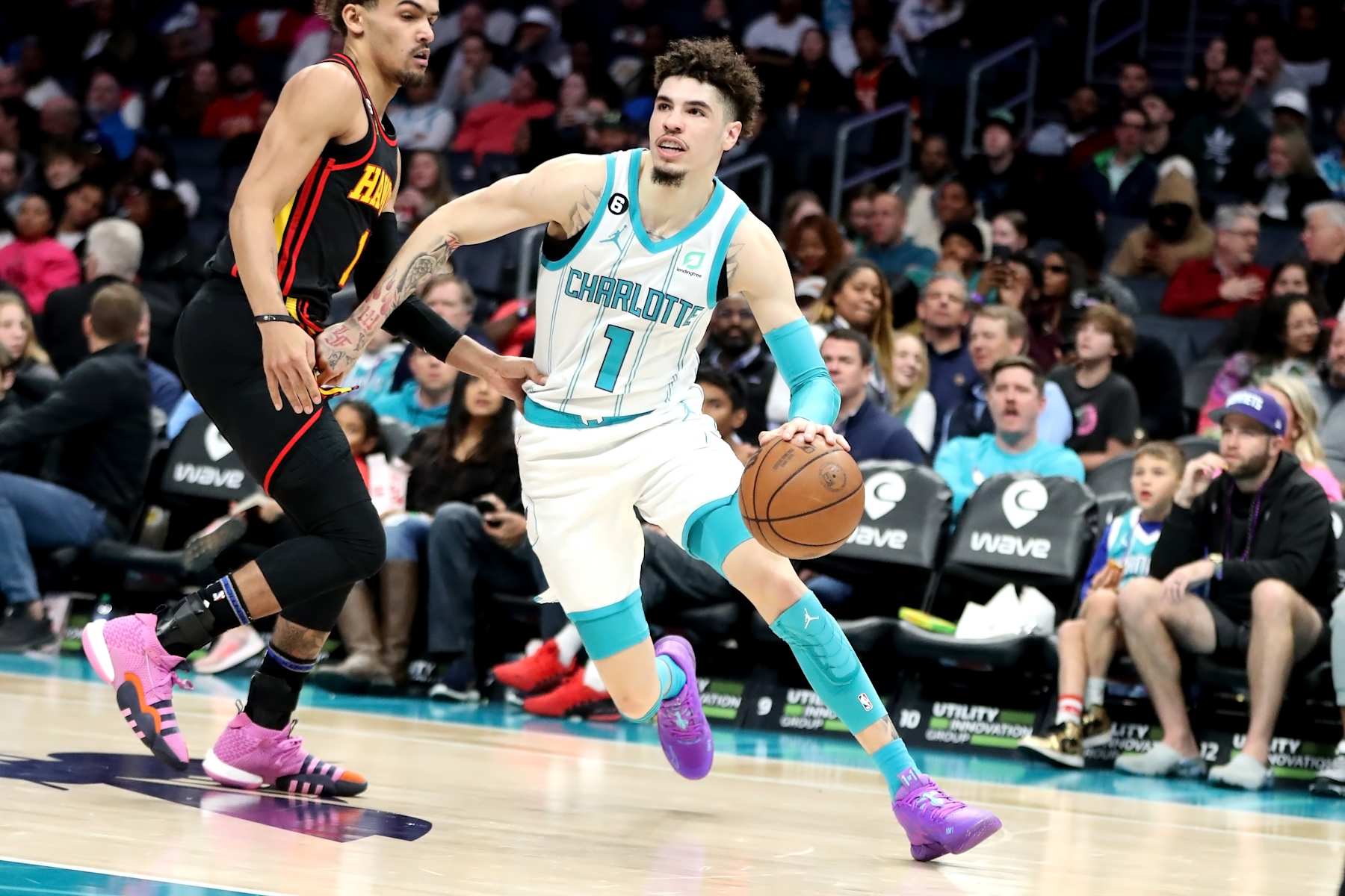 CHARLOTTE, NORTH CAROLINA - FEBRUARY 13: Trae Young #11 of the Atlanta Hawks defends LaMelo Ball #1 of the Charlotte Hornets as he drives to the basket during the second period of a basketball game at Spectrum Center on February 13, 2023 in Charlotte, North Carolina. NOTE TO USER: User expressly acknowledges and agrees that, by downloading and or using this photograph, User is consenting to the terms and conditions of the Getty Images License Agreement. (Photo by David Jensen/Getty Images)