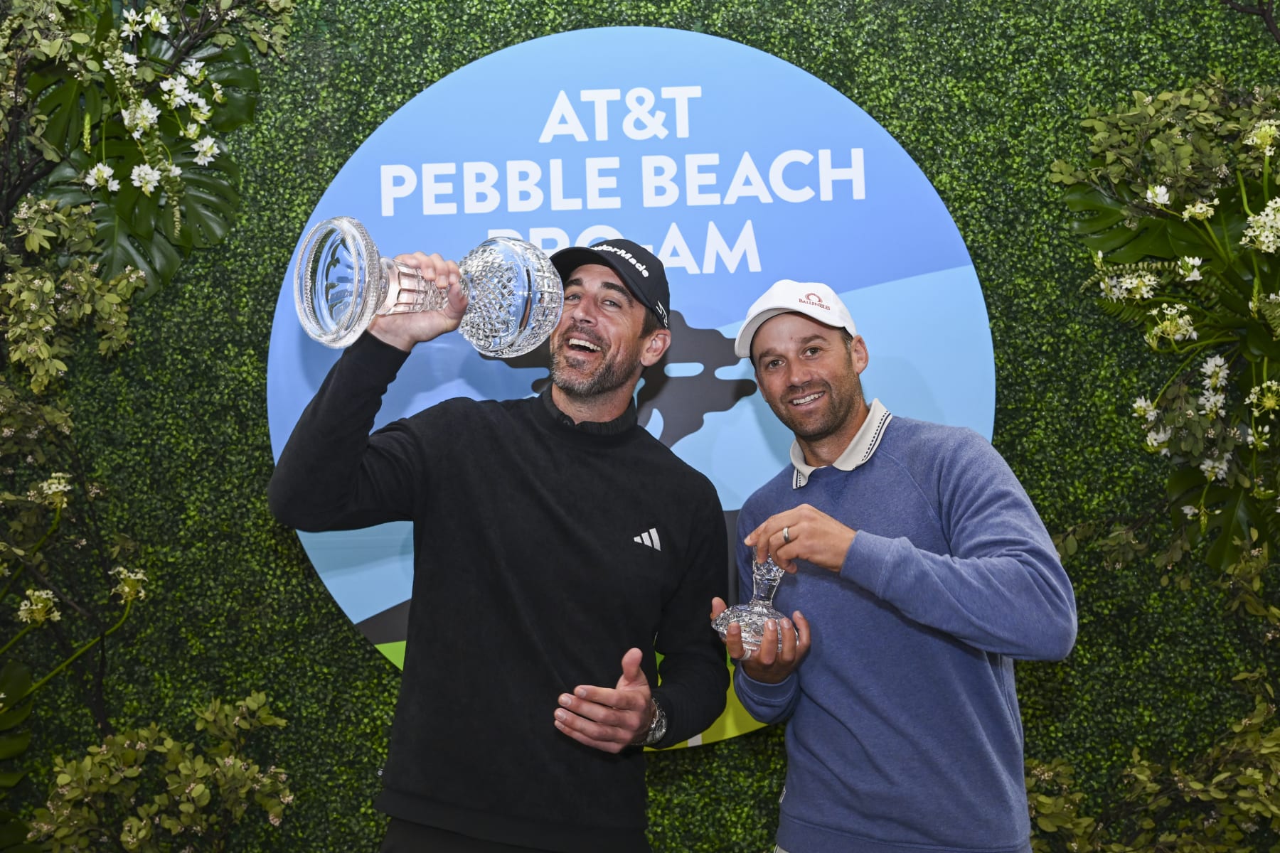 PEBBLE BEACH, CALIFORNIA - FEBRUARY 05: Green Bay Packers quarterback, Aaron Rodgers, has a little fun with his playing partner, Ben Silverman, with the trophy after the continuation of the third round of the AT&T Pebble Beach Pro-Am at Pebble Beach Golf Links on February 5, 2023 in Pebble Beach, California. (Photo by Tracy Wilcox/PGA TOUR via Getty Images)