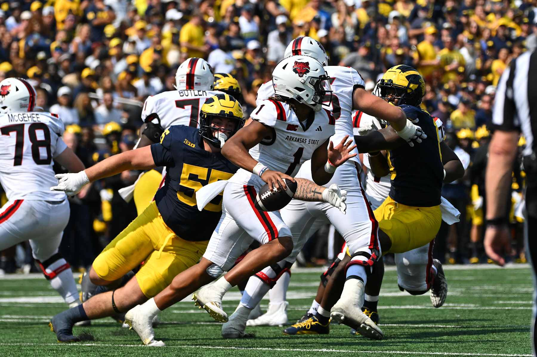 DETROIT, MI - SEPTEMBER 15: Arkansas State Red Wolves quarterback Jaylen Raynor (1) is chased by Michigan Wolverines defensive lineman Mason Graham (55) during the Detroit Lions versus the Tampa Bay Buccaneers game on Sunday September 15, 2024 at Ford Field in Detroit, MI. (Photo by Steven King/Icon Sportswire via Getty Images)
