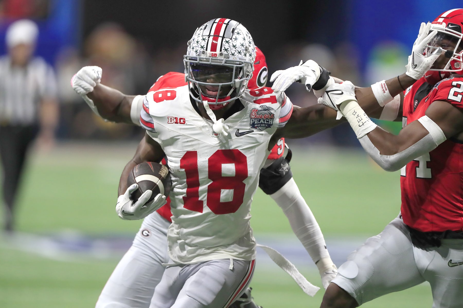 ATLANTA, GA - DECEMBER 31: Ohio State Buckeyes wide receiver Marvin Harrison Jr. (18) fends off the Georgia Bulldogs defensive unit during the college football playoff semifinal game between the University of Georgia Bulldogs and The Ohio State Buckeyes on December 31, 2022 at the Mercedes-Benz Stadium in Atlanta, GA.  (Photo by David J. Griffin/Icon Sportswire via Getty Images)