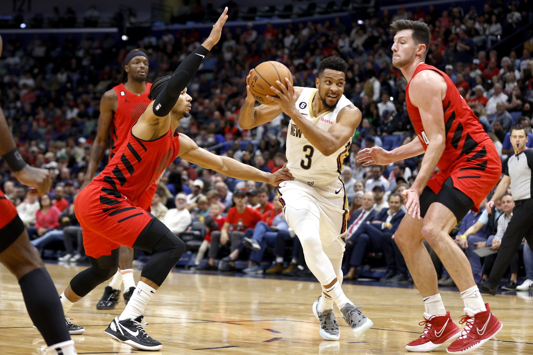 NEW ORLEANS, LOUISIANA - NOVEMBER 10: CJ McCollum #3 of the New Orleans Pelicans drives the lane as he is defneded by Josh Hart #11 of the Portland Trail Blazers and Drew Eubanks #24 of the Portland Trail Blazers during the second quarter of an NBA game at Smoothie King Center on November 10, 2022 in New Orleans, Louisiana. NOTE TO USER: User expressly acknowledges and agrees that, by downloading and or using this photograph, User is consenting to the terms and conditions of the Getty Images License Agreement. (Photo by Sean Gardner/Getty Images)