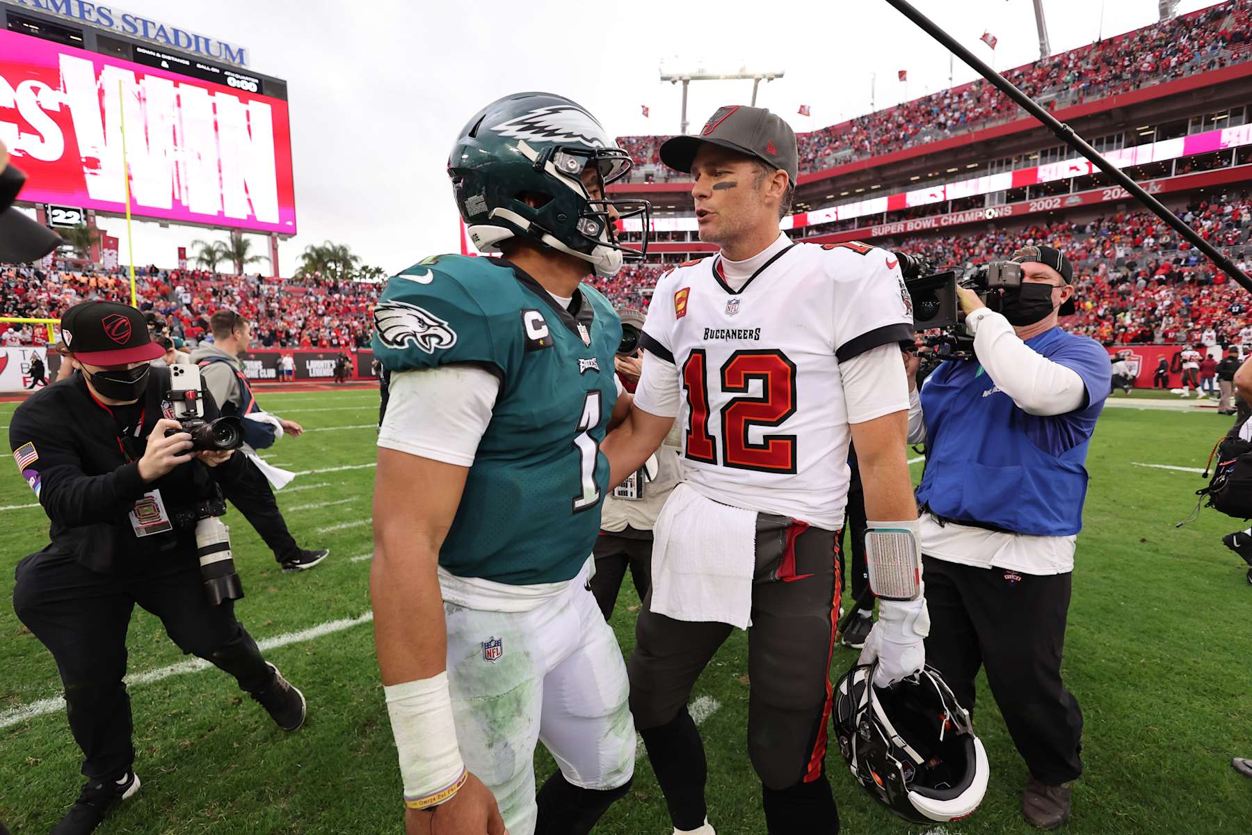 TAMPA, FL - JANUARY 16: Tom Brady #12 of the Tampa Bay Buccaneers and Jalen Hurts #1 of the Philadelphia Eagles talk after the NFC Wild Card playoff game at Raymond James Stadium on January 16, 2022 in Tampa, Florida. (Photo by Perry Knotts/Getty Images)