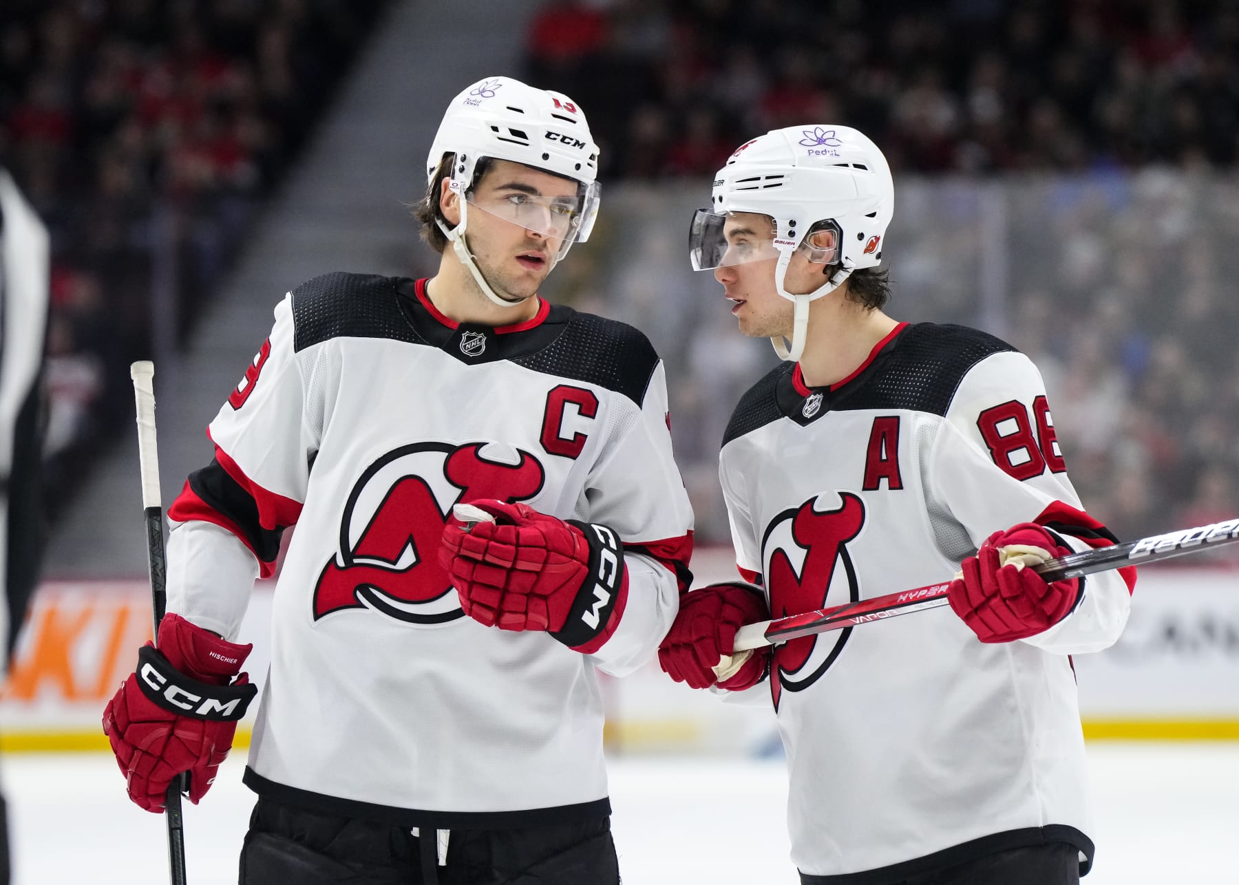 OTTAWA, CANADA - APRIL 6:  Nico Hischier #13 of the New Jersey Devils talks with teammate Jack Hughes #86 in a game against the Ottawa Senators at Canadian Tire Centre on April 6, 2024 in Ottawa, Ontario, Canada.  (Photo by Andrea Cardin/NHLI via Getty Images)
