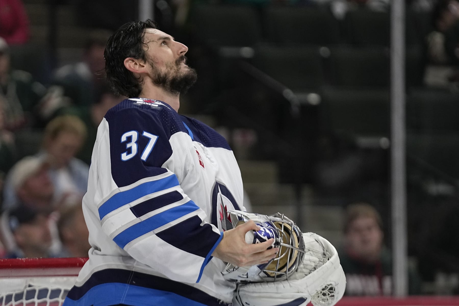 Winnipeg Jets goaltender Connor Hellebuyck (37) looks up at the video board during the third period of an NHL hockey game against the Minnesota Wild, Tuesday, April 11, 2023, in St. Paul, Minn. (AP Photo/Abbie Parr)