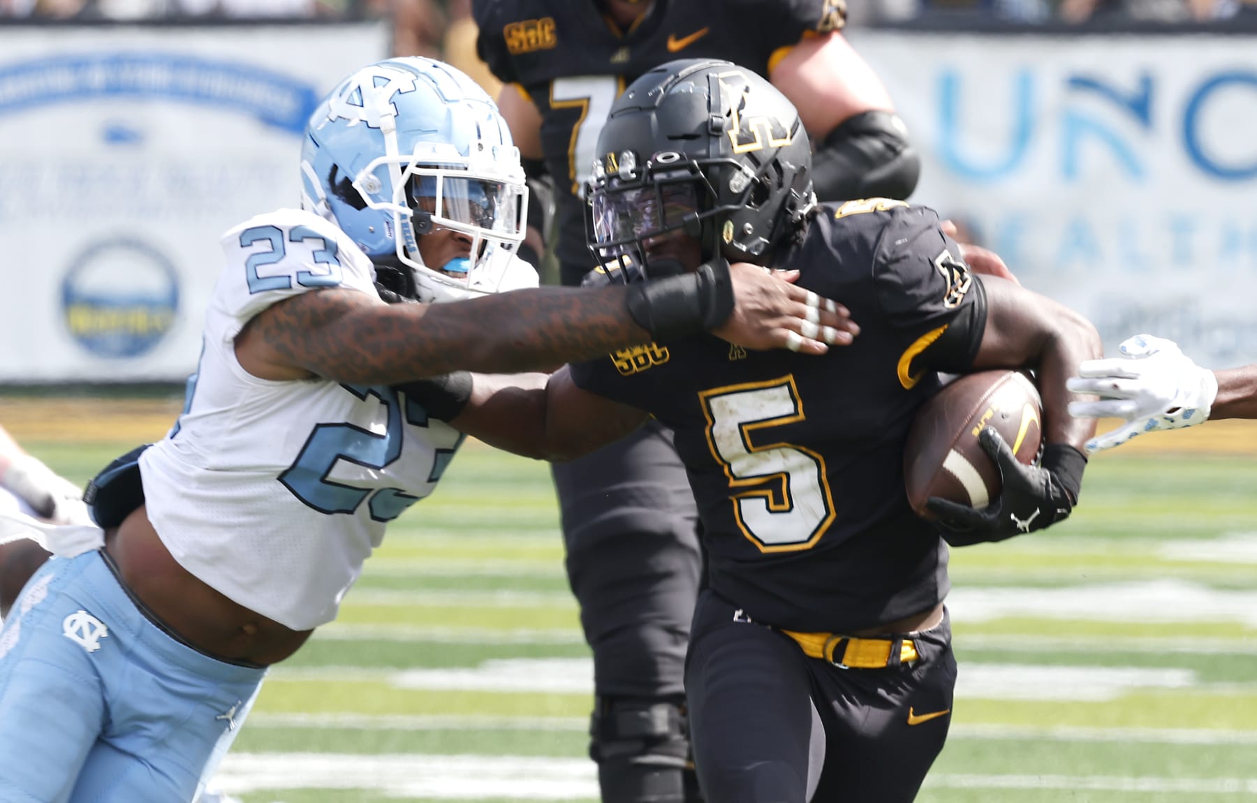 Appalachian State running back Nate Noel (5) runs past North Carolina linebacker Power Echols (23) during the second half of an NCAA college football game, Saturday Sept. 3, 2022, in Boone, N.C. (AP Photo/Reinhold Matay)